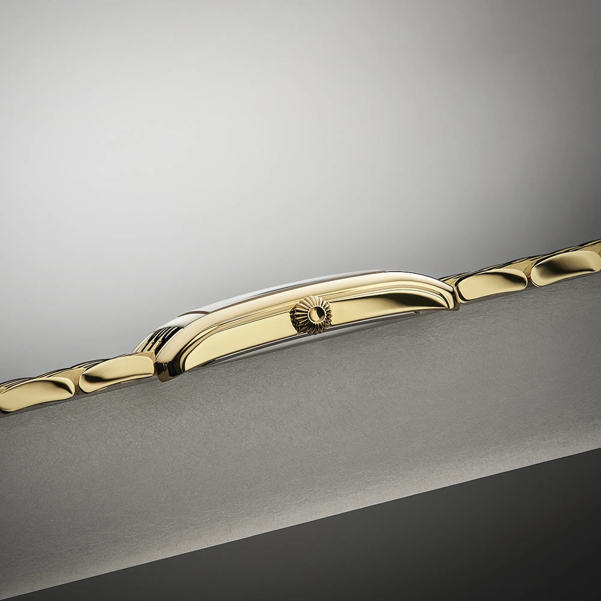 Produktfotografie der Frontale Ansicht der goldfarbenen Frederique Constant Classics Carree Small Seconds Armbanduhr mit rechteckigem Gehäuse im Art-Deco-Stil und römischen Indizes zeigt das seitliche Gehäuse und die Aufzugskrone