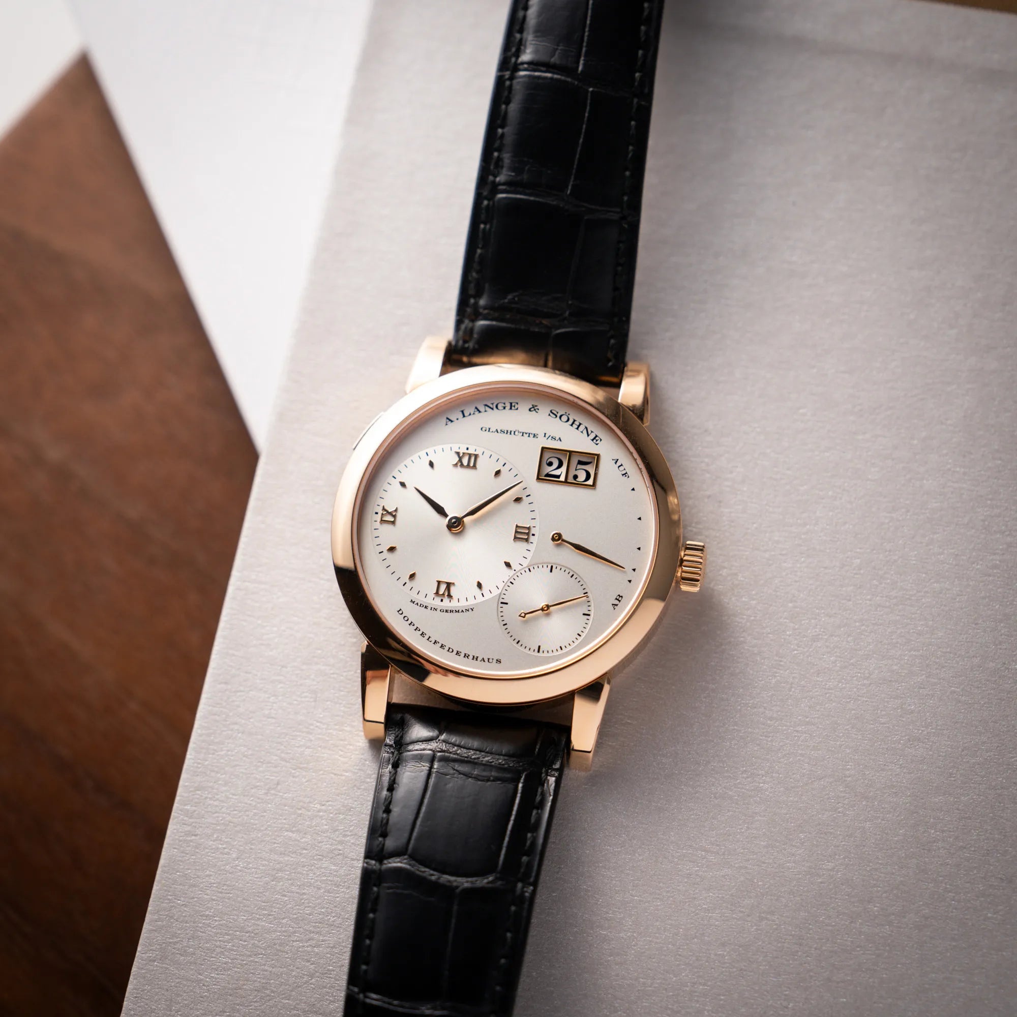 Produktfotografie als Titelbild für die A. Lange & Söhne Lange 1 der Referenz 101.032 mit 38,5mm-Roségold-Gehäuse und dem für das Modell typische, asymmetrisch angeordnete Zifferblatt mit Großdatum