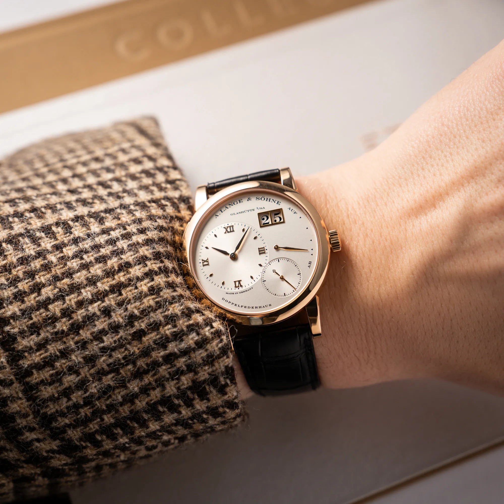 Mann trägt die A. Lange & Söhne Lange 1 der Referenz 101.032 mit 38,5mm-Roségold-Gehäuse und dem für das Modell typische, asymmetrisch angeordnete Zifferblatt mit Großdatum für einen Wristshot an seinem Handgelenk