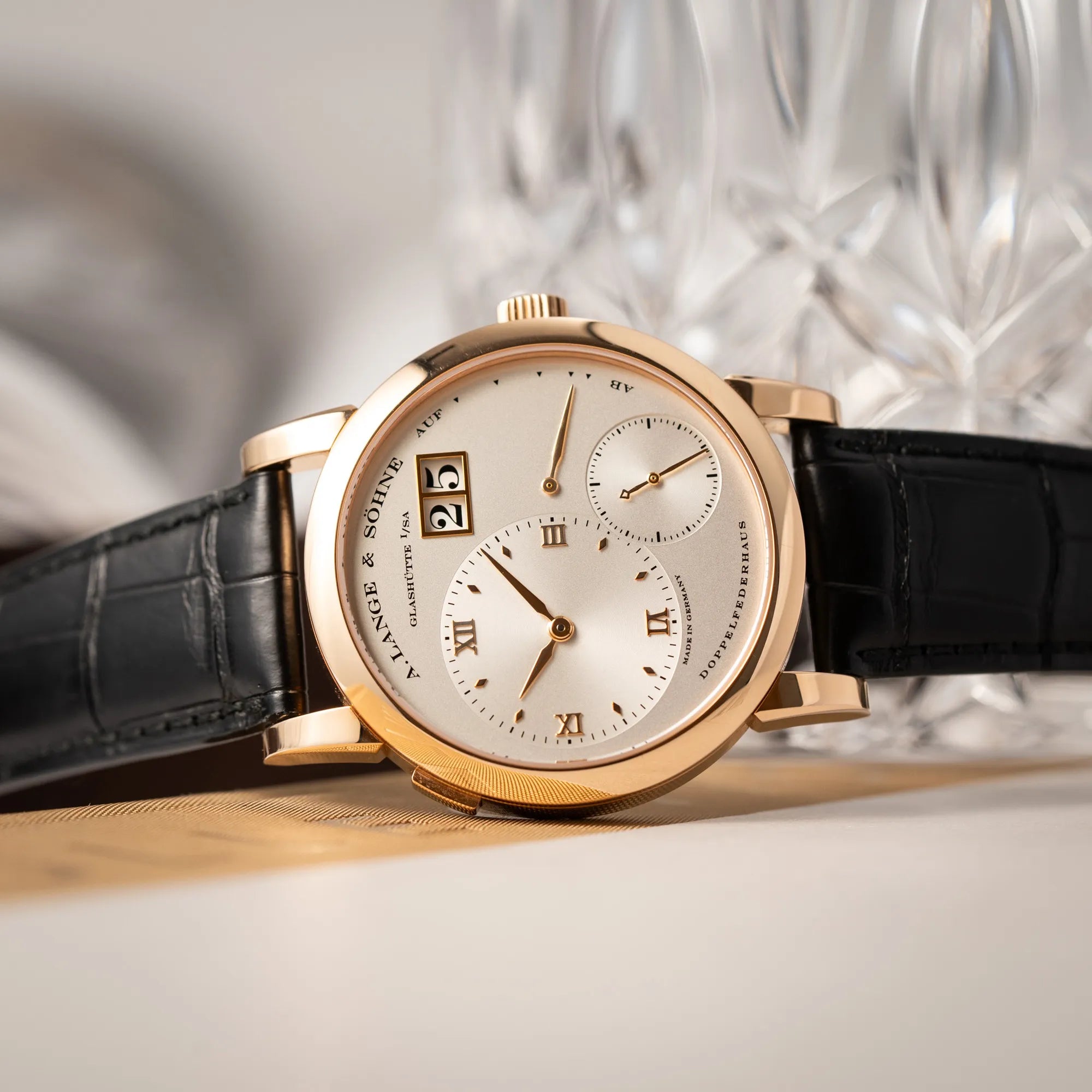 Produktfotografie der A. Lange & Söhne Lange 1 der Referenz 101.032 mit 38,5mm-Roségold-Gehäuse und dem für das Modell typische, asymmetrisch angeordnete Zifferblatt mit Großdatum