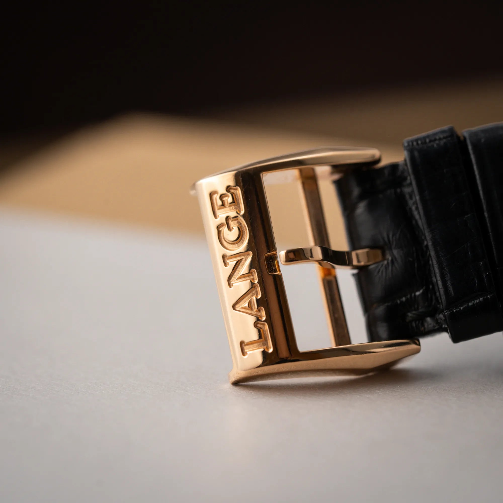 Detailaufnahme der rosegoldenen Dornschliesse mit Lange-Schriftzug von der A. Lange & Söhne Lange 1 der Referenz 101.032 mit 38,5mm-Roségold-Gehäuse und dem für das Modell typische, asymmetrisch angeordnete Zifferblatt mit Großdatum