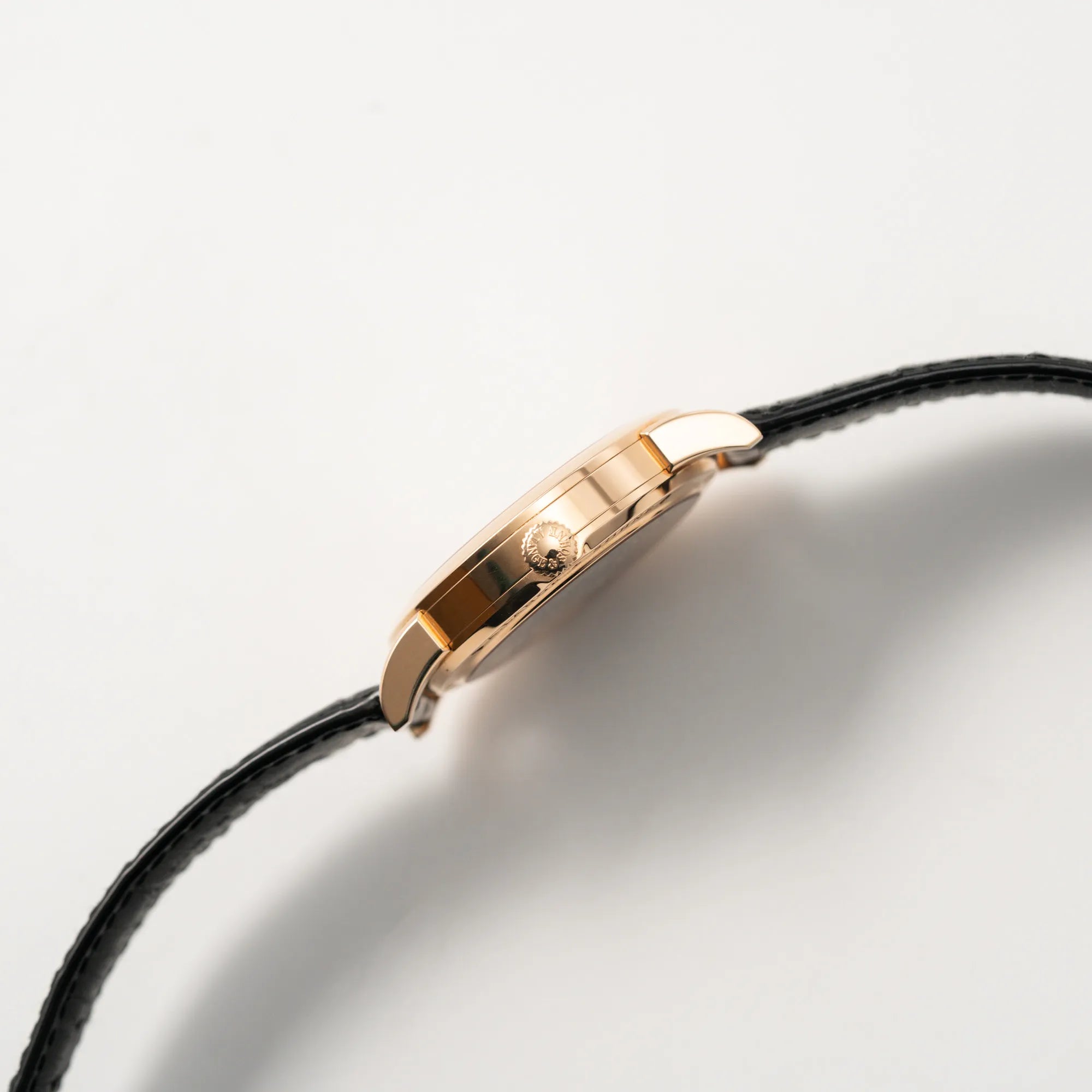 Seitliche Gehäuseflanke mit Blick auf die Aufzugskrone der A. Lange & Söhne Lange 1 der Referenz 101.032 mit 38,5mm-Roségold-Gehäuse und dem für das Modell typische, asymmetrisch angeordnete Zifferblatt mit Großdatum