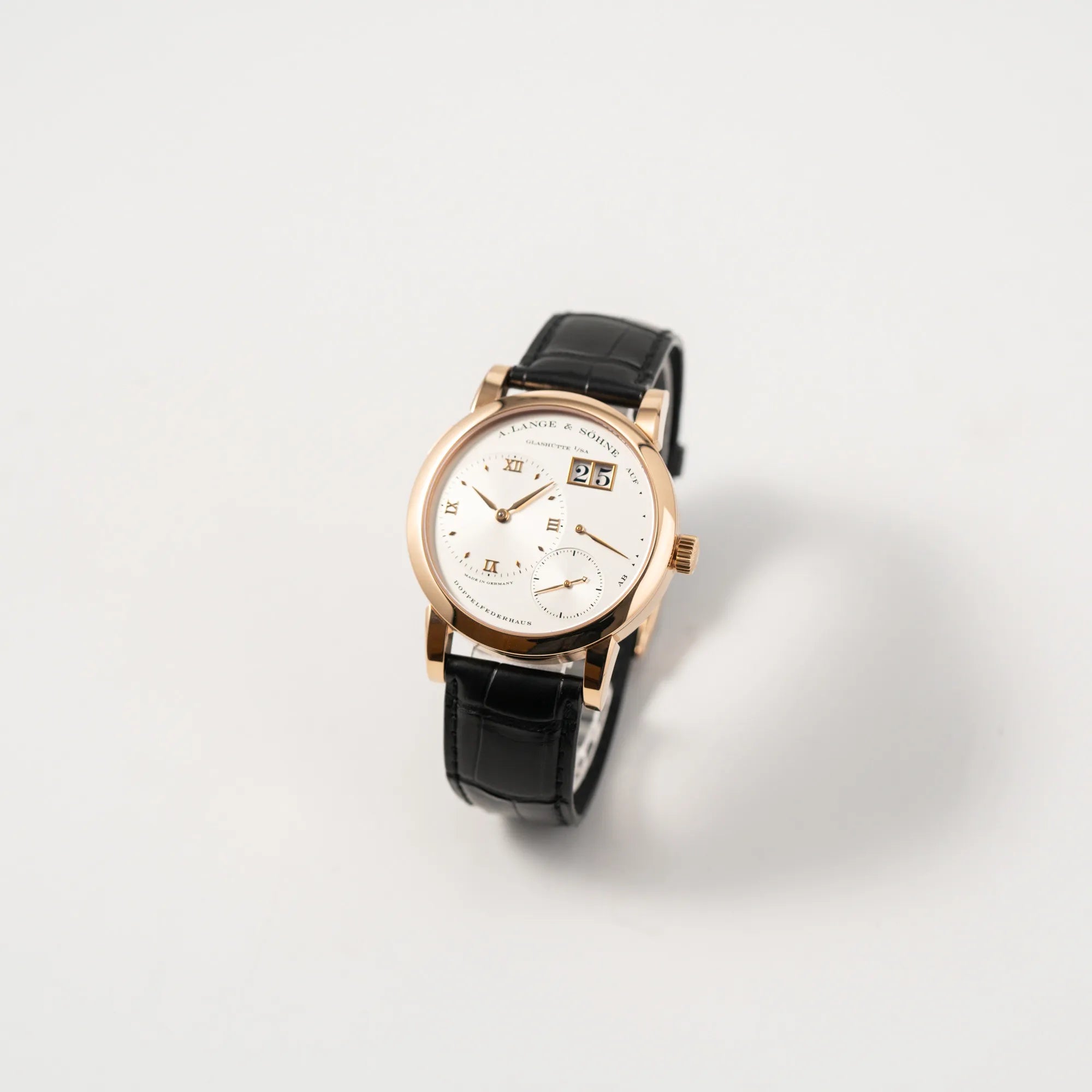 Leicht schräge Ansicht der A. Lange & Söhne Lange 1 der Referenz 101.032 mit 38,5mm-Roségold-Gehäuse und dem für das Modell typische, asymmetrisch angeordnete Zifferblatt mit Großdatum