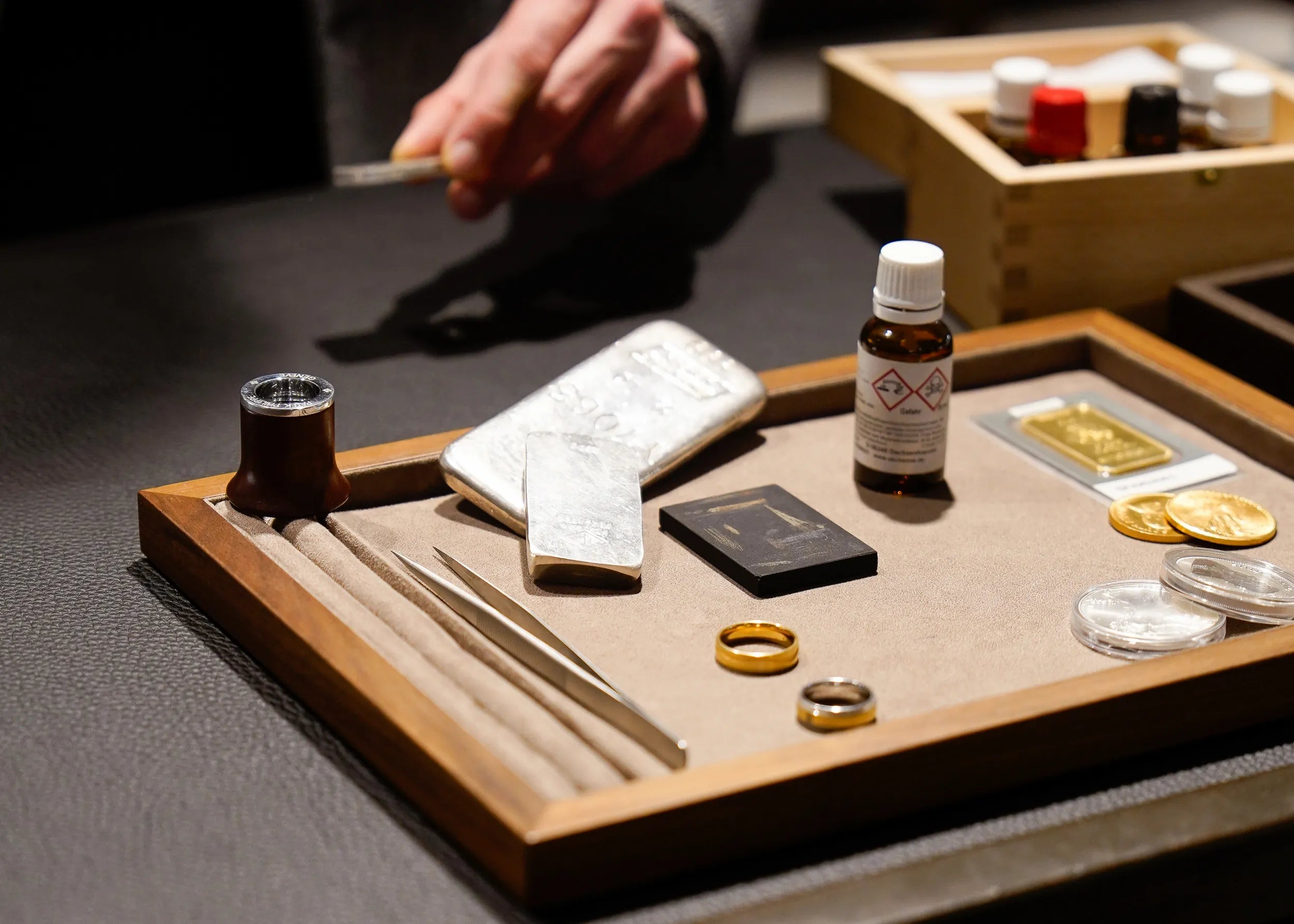 Tablet mit Goldringen aus Altgold-Bestand, Silberbarren, sowie Goldmünzen und einem Goldbarren, zusammen mit Prüfstein für Gold-Legierung