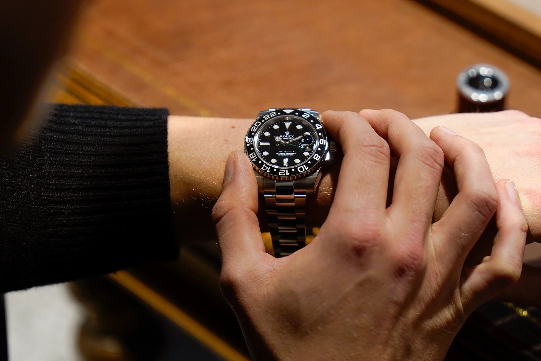 Kunde probiert schwarze GMT Master von Rolex im Ladengeschäft bei einem Besichtigungstermin für Luxusuhren an
