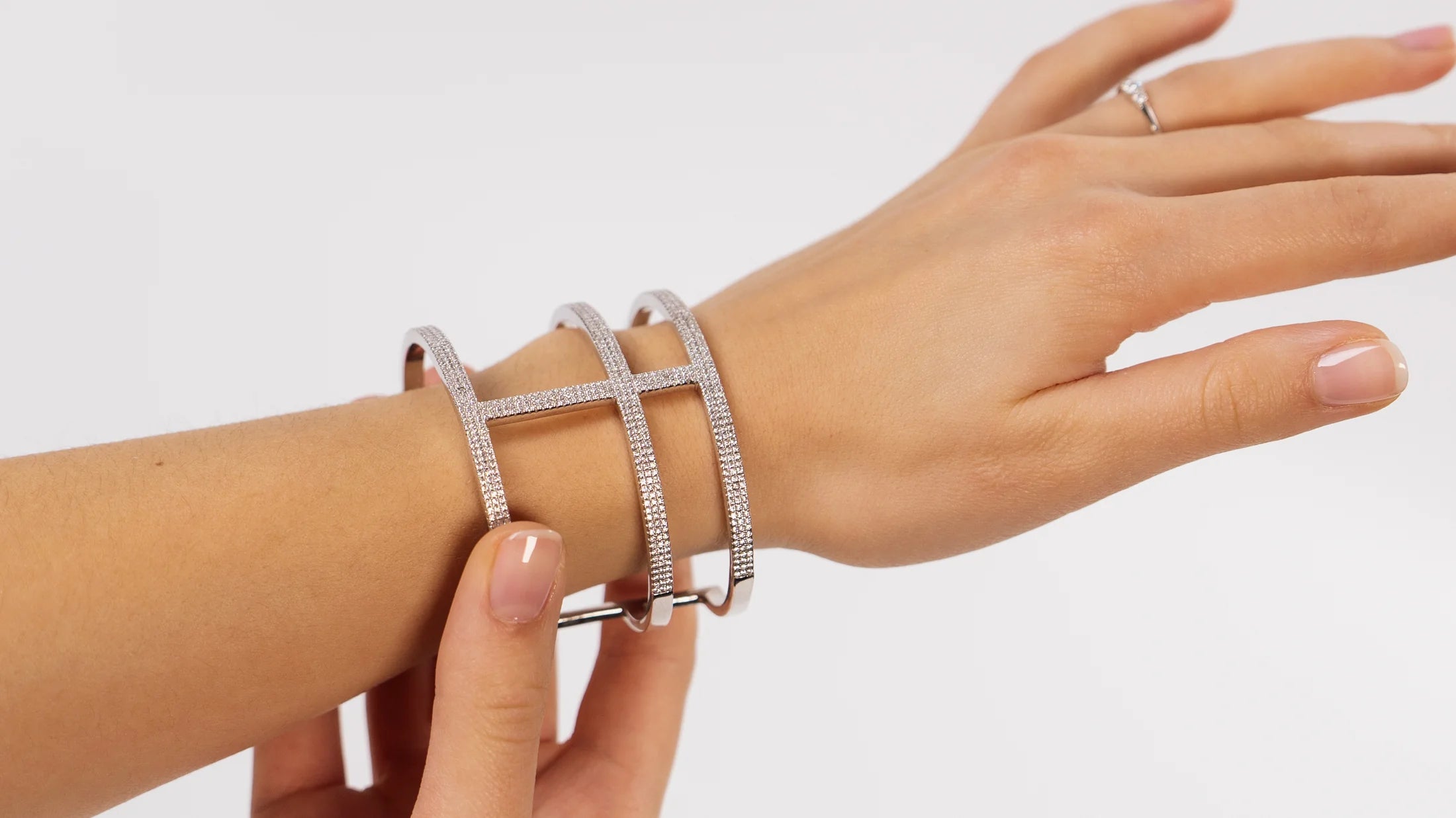 Frau trägt Armreif in Weissgold mit Diamant Besatz am Handgelenk