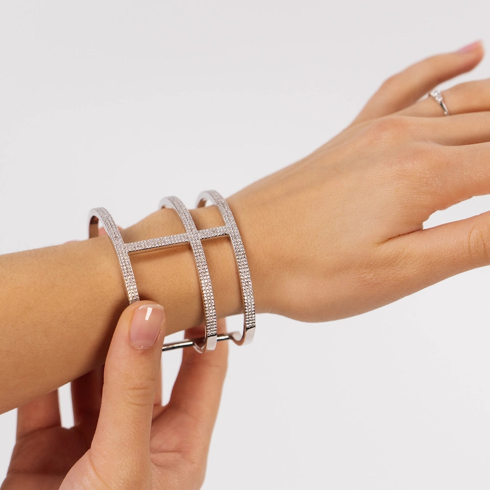 Frau rückt einen diamantbesetzten Armreif an Ihrem Handgelenk zurecht