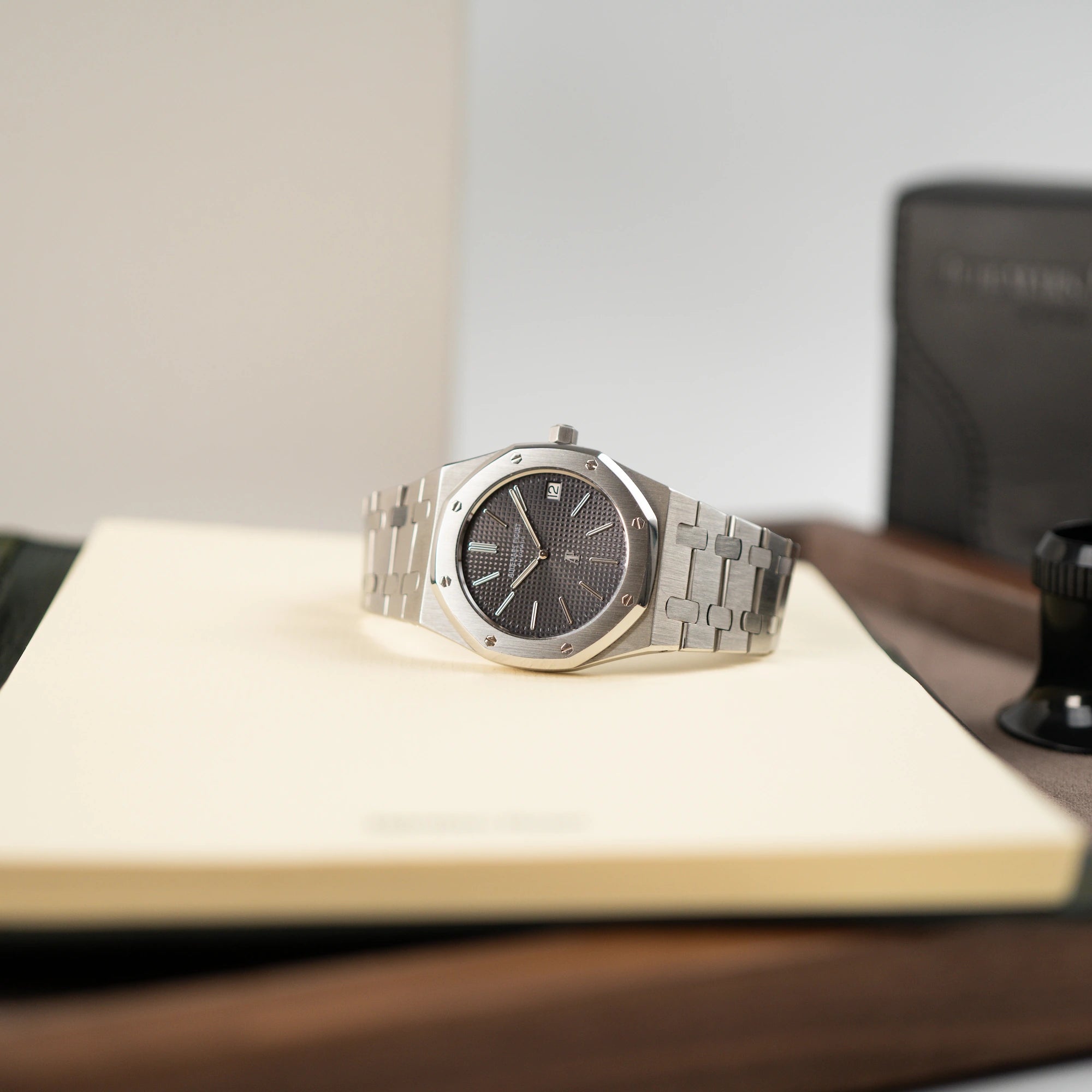 Audemars Piguet Royal Oak Royal Oak 5402ST aus der B-Serie in Stahl liegt auf einem Buch mit gelben Seiten