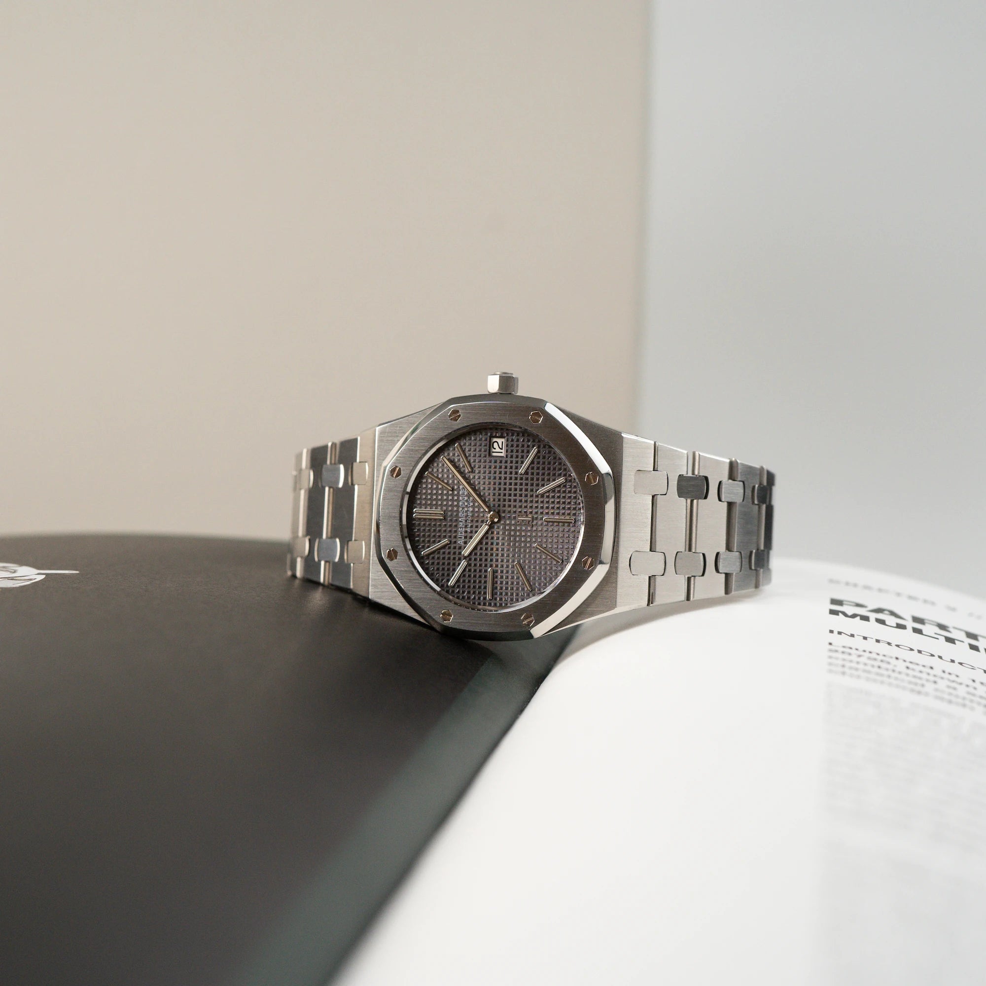 Audemars Piguet Royal Oak Royal Oak 5402ST aus der B-Serie in Stahl liegt auf einem Buch mit schwarzer und weißer Seite