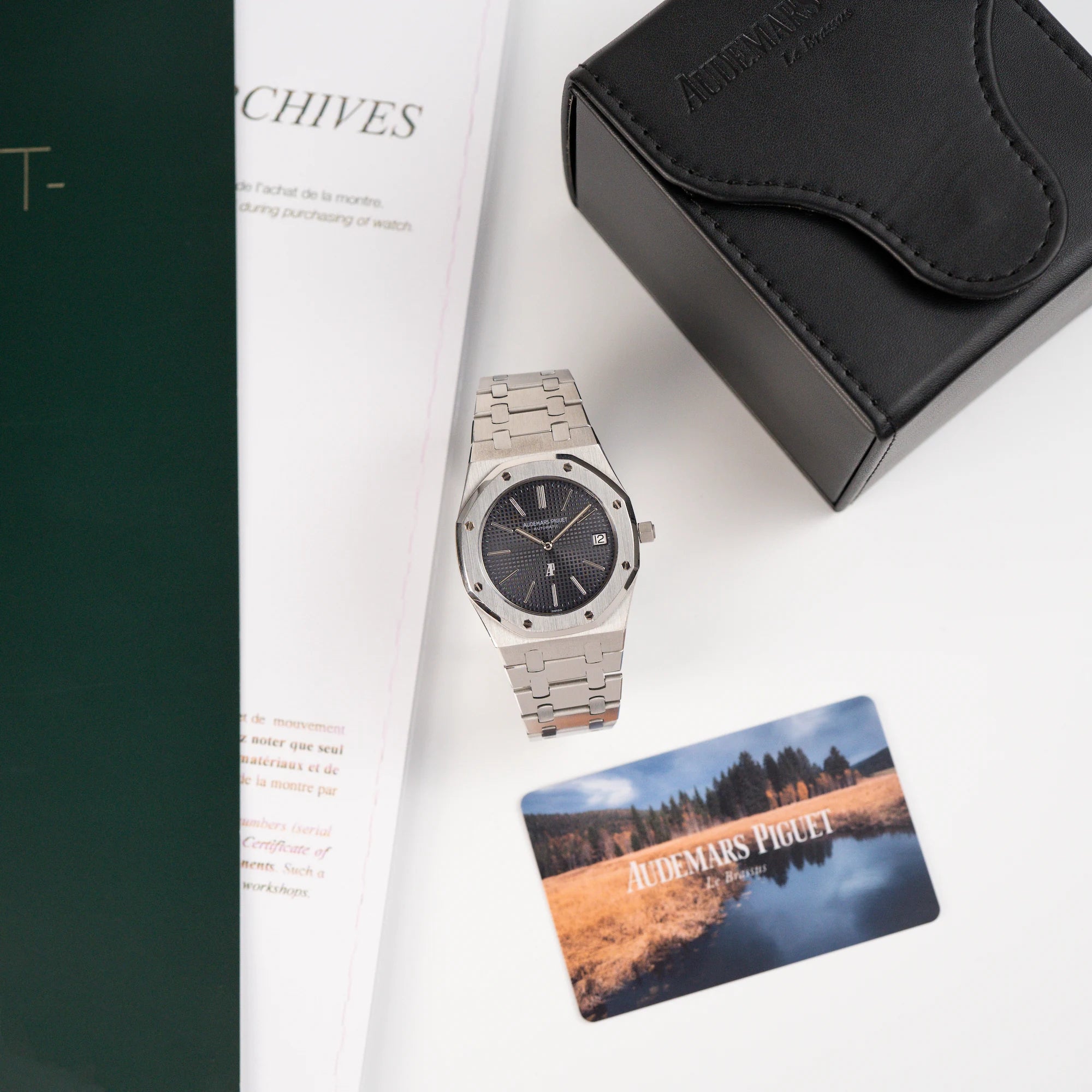 Audemars Piguet Royal Oak 5402ST aus der B-Serie in Stahl steht neben der Uhrenbox und daneben stehen Booklet und Zertifikat der Uhr