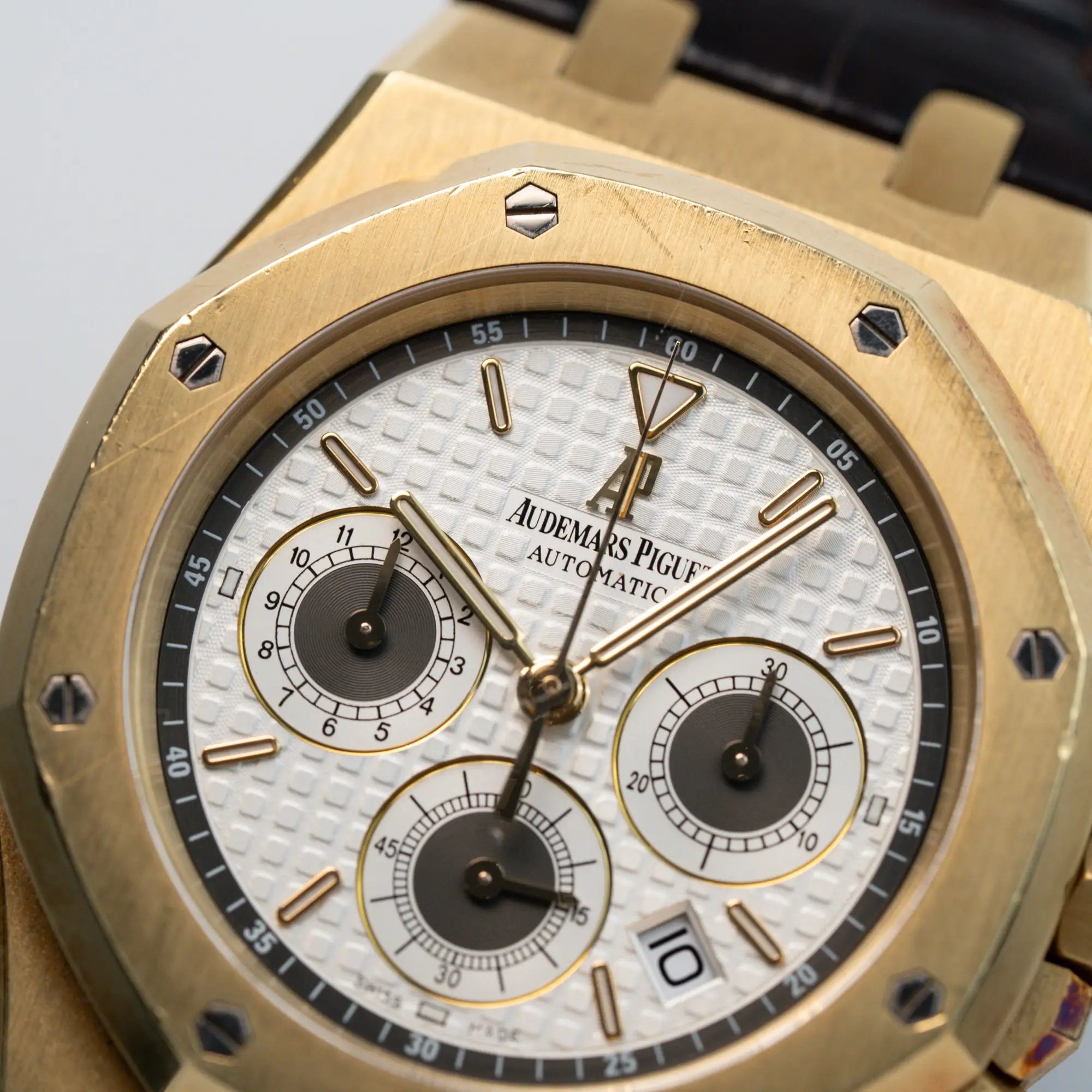 Detailaufnahme des weißen Zifferblatts mit Tapisserie des gelbgoldenen Royal Oak Chronograph von Audemars Piguet mit einem 39mm Gehäuse