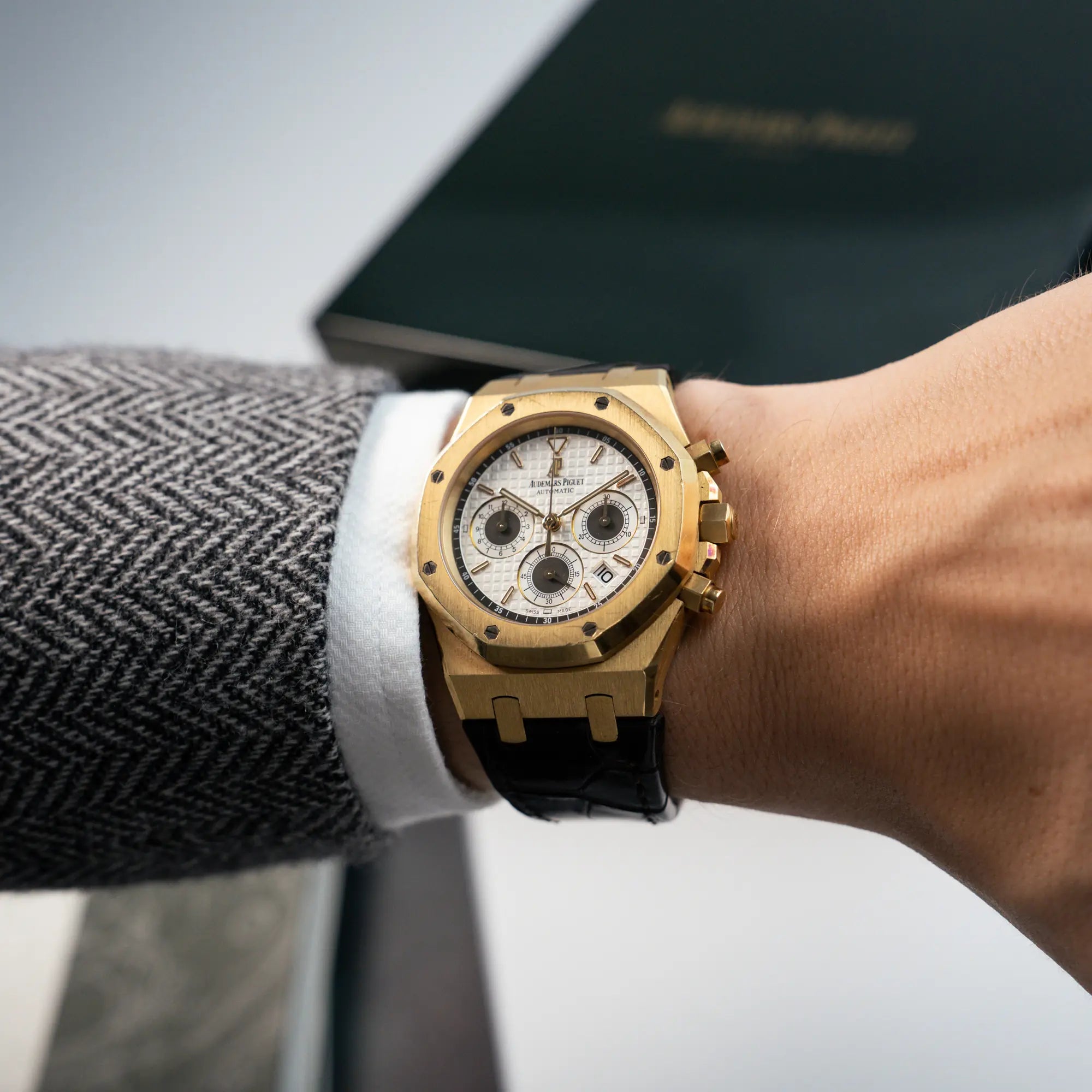 Mann trägt den gelbgoldenen Royal Oak Chronographs von Audemars Piguet mit einem 39mm Gelbgold-Gehäuse und braunen Lederband an seinem Handgelenk