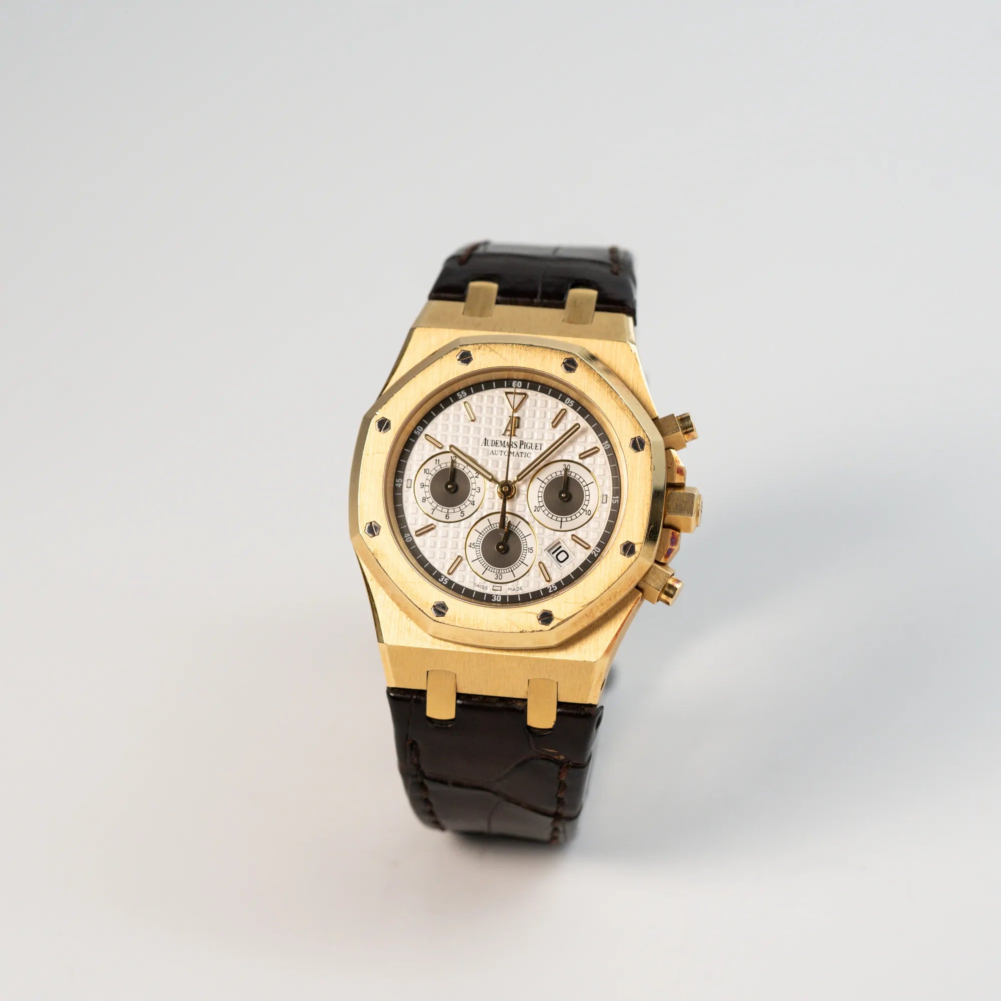 Leicht seitliche Ansicht des gelbgoldenen Royal Oak Chronographen von Audemars Piguet mit 39mm Gehäusedurchmesser an einem dunkelbraunen Lederband