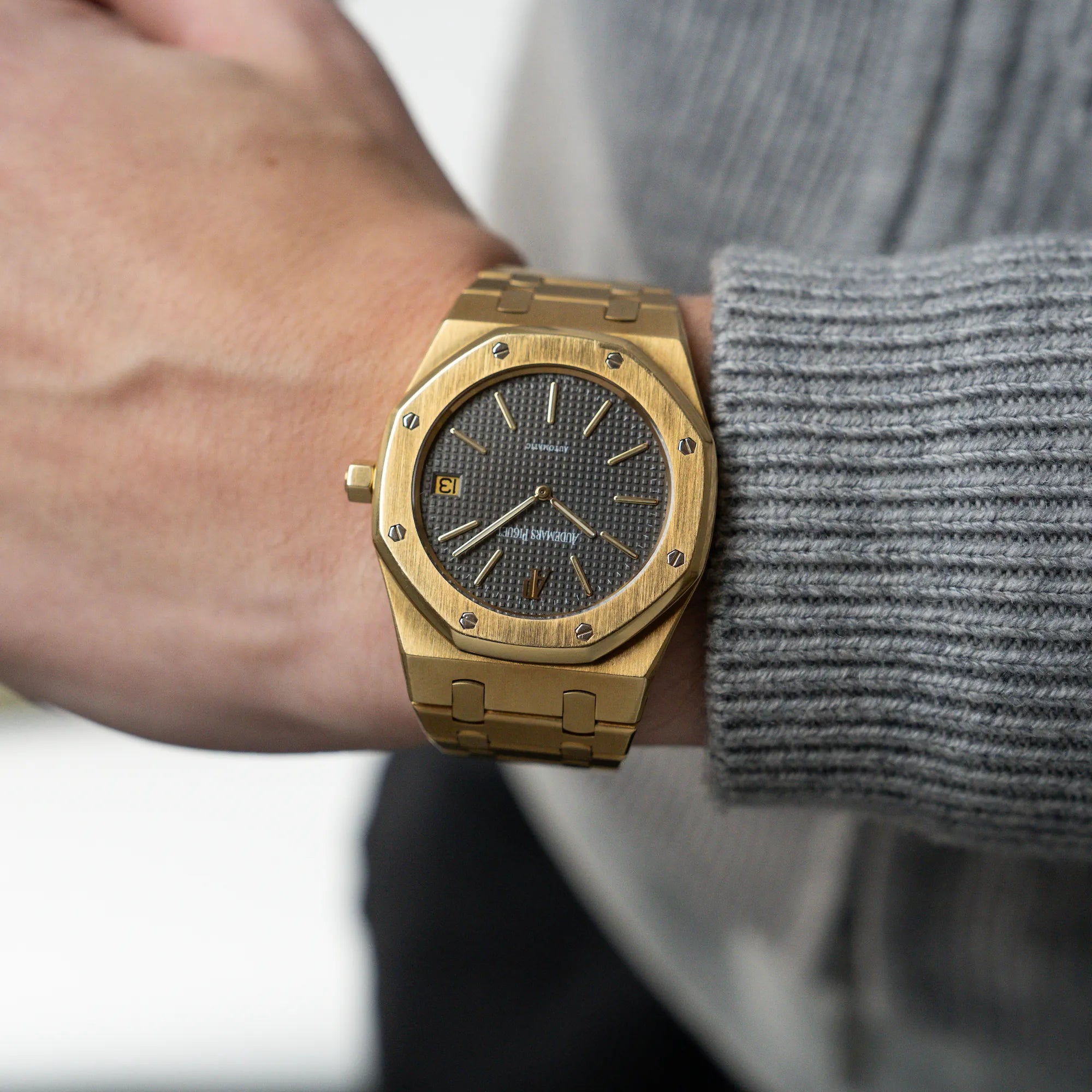 Mann trägt Audemars Piguet Royal Oak Jumbo 14802BA Jubilee in Gelbgold an seinem Handgelenk und präsentiert die Uhr