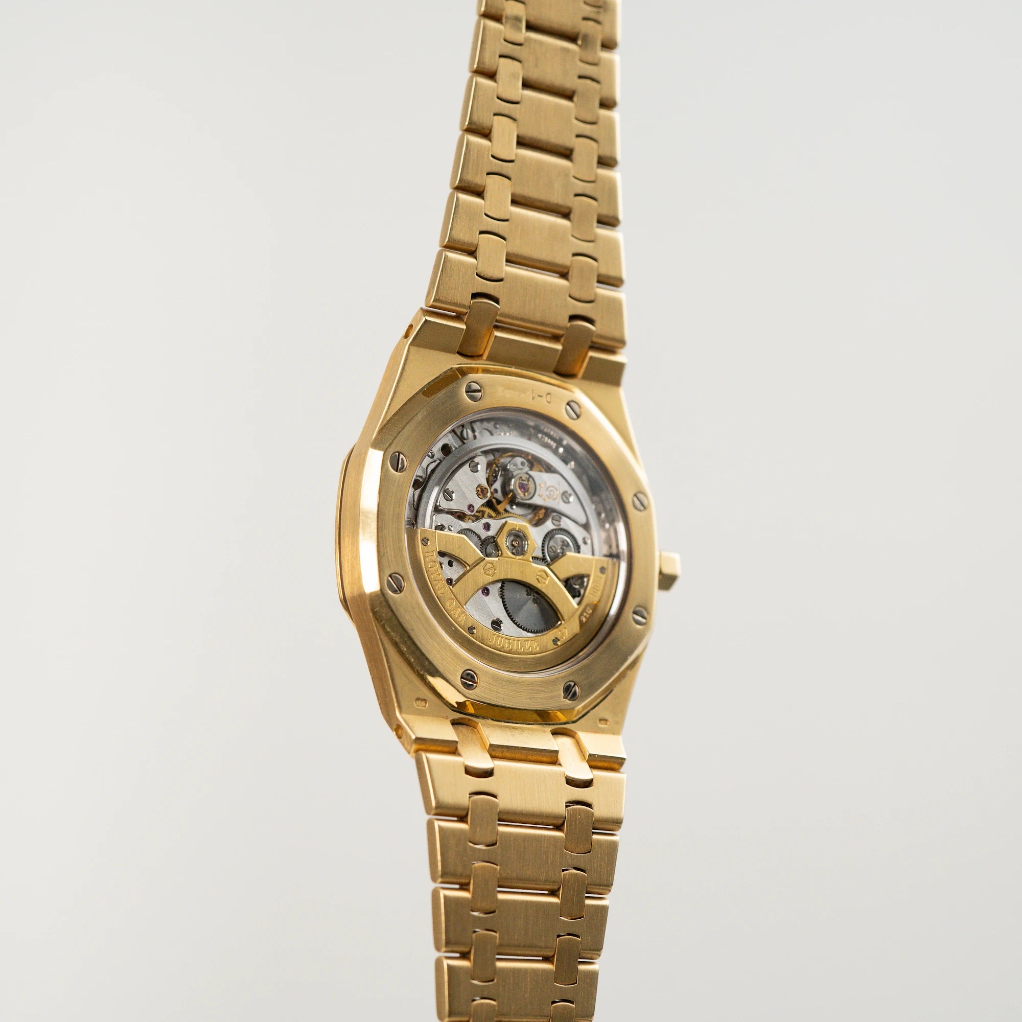 Blick auf das Caseback der Audemars Piguet Royal Oak Jumbo 14802BA Jubilee in Gelbgold, die schwebt in der Luft mit offener Schließe