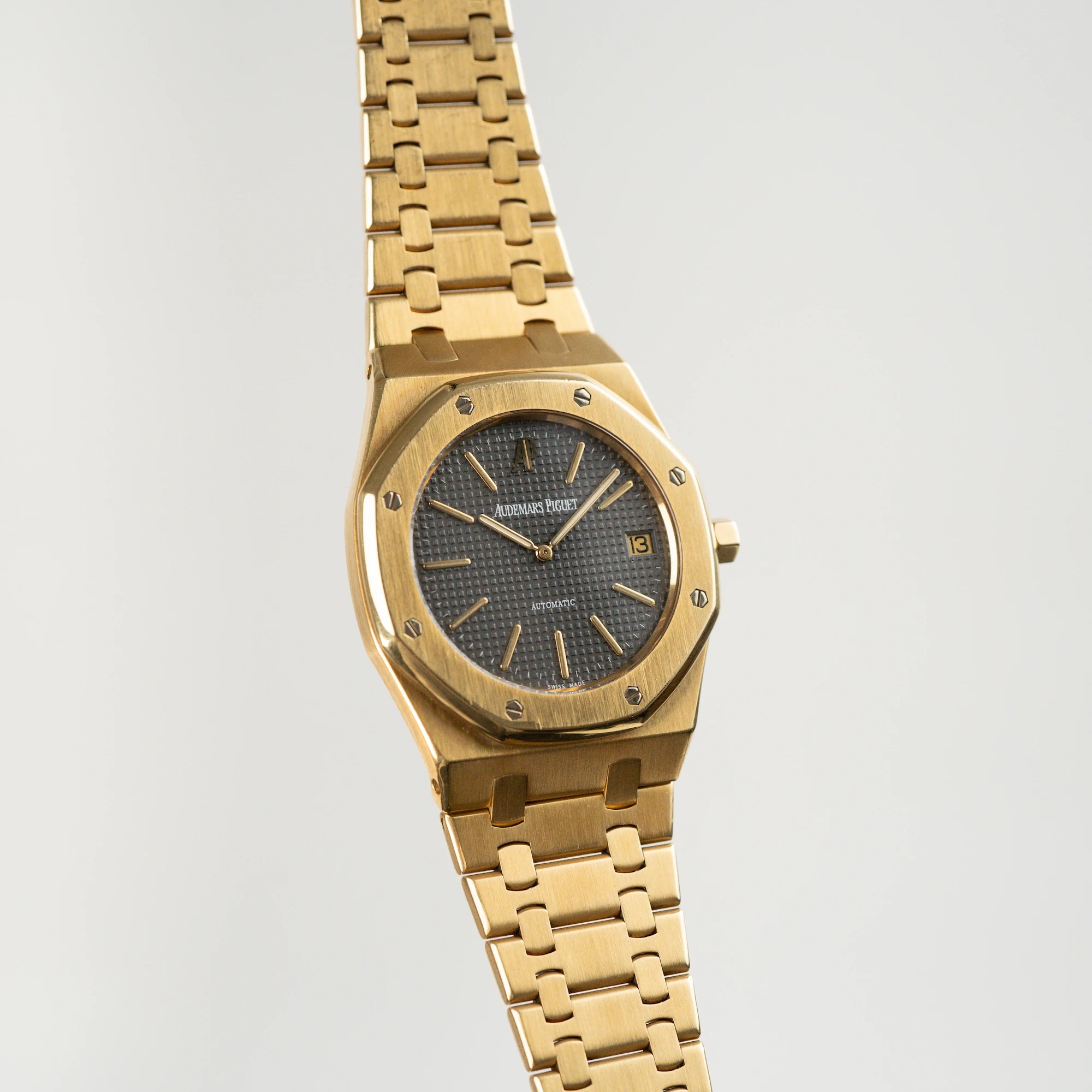 Frontaler Blick auf Audemars Piguet Royal Oak Jumbo 14802BA Jubilee in Gelbgold, die schwebt in der Luft mit offener Schließe