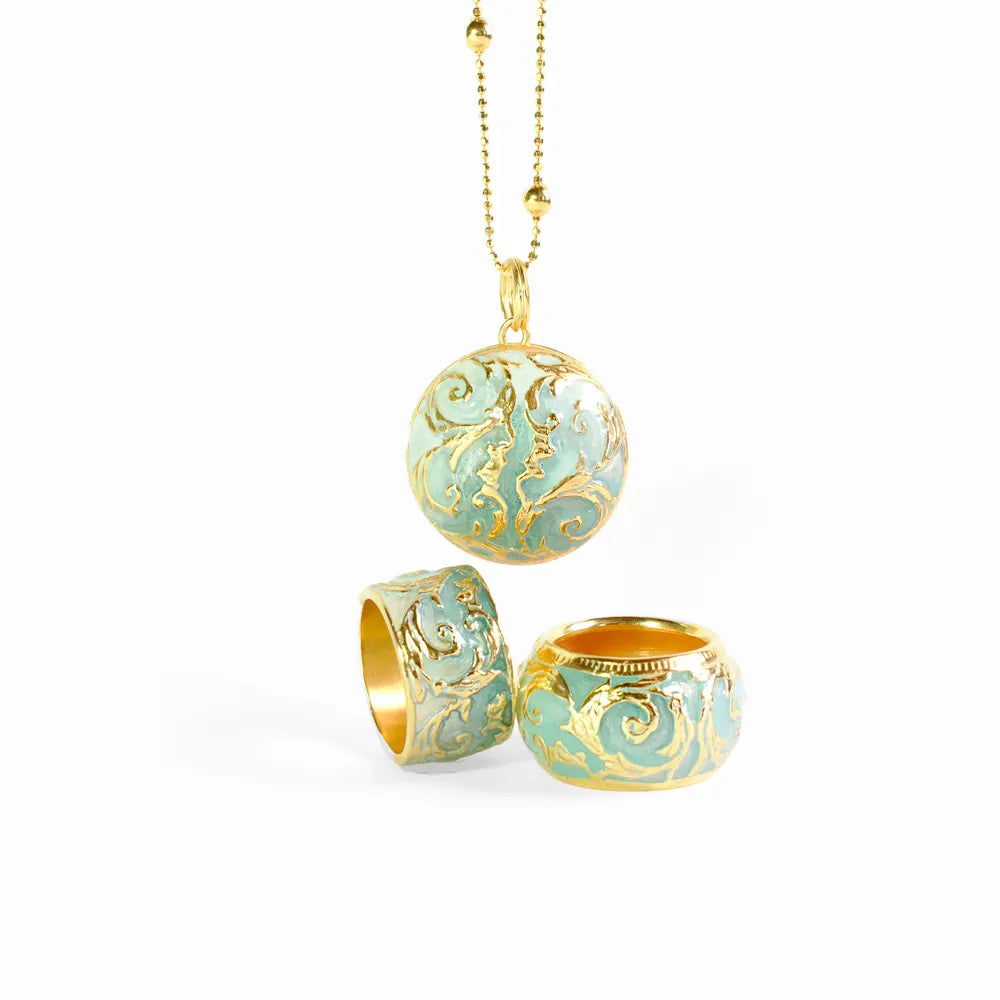 Produktfotografie des Barbara Hass Design Schmucksets, betserhend aus zwei Ringen und einem Collier, welches mit hellblau-türkisem Lack verziert und veredelt wurde