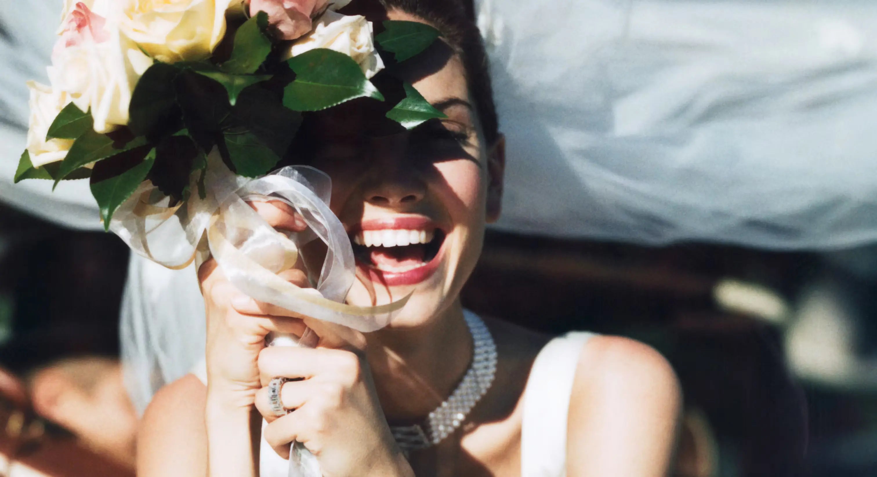 Frau mit Brautstrauß in der Hand, die an Ihrem Hochzeitstag sehr beschmückt ist