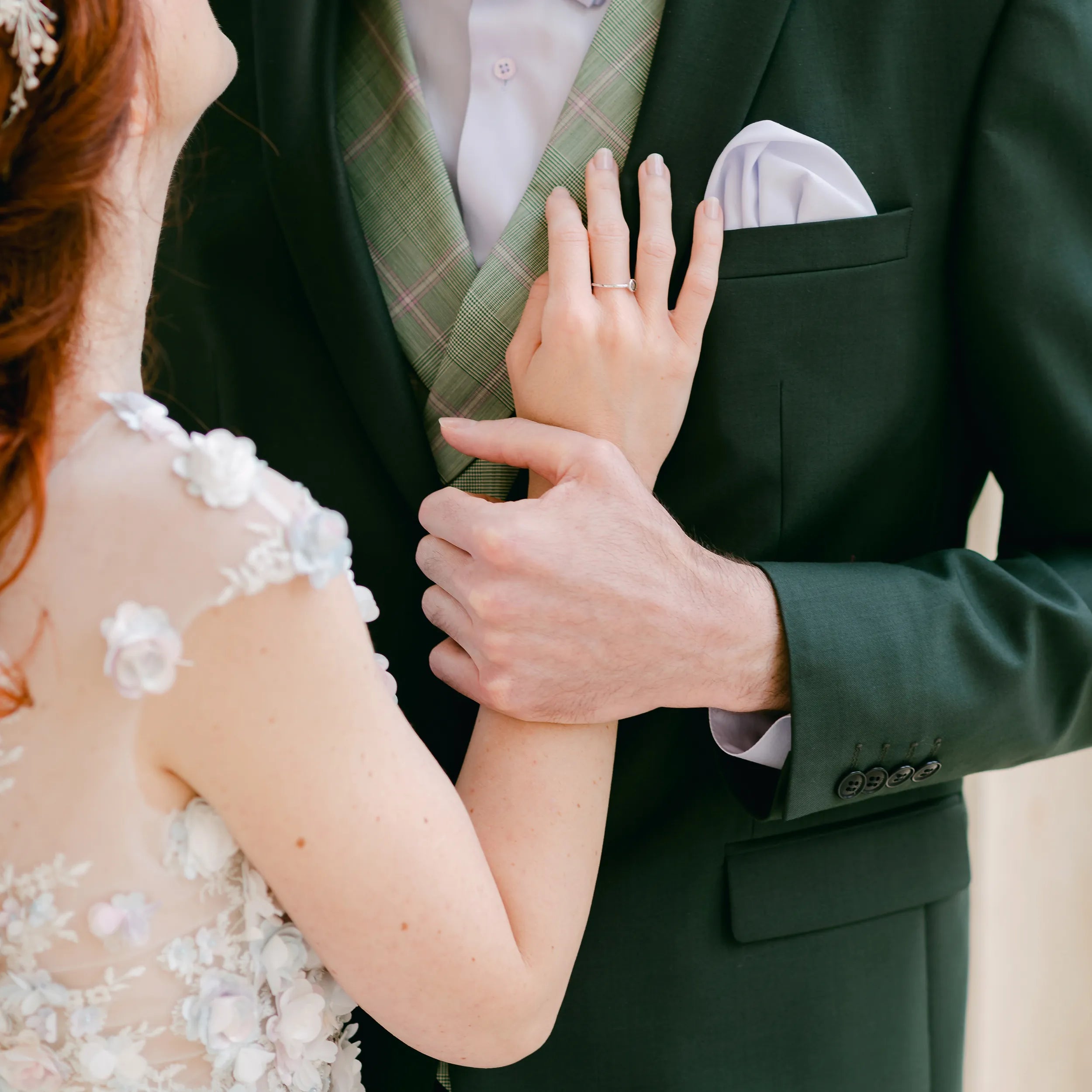 Brautpaar steht sich am Hochzeitstag gegenüber und deren Hände berühren sich 