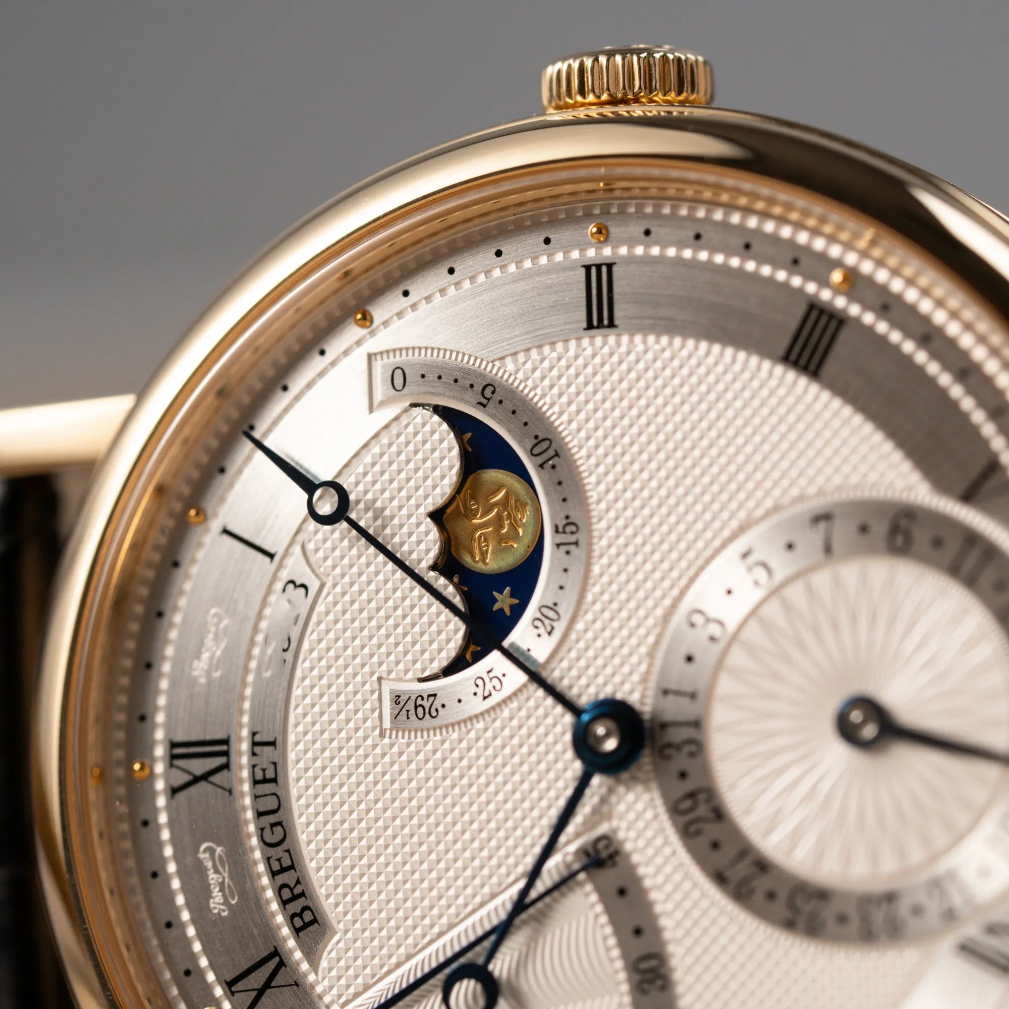 Detailaufnahme der Mondphase-Anzeige der Breguet Classique 7137BA mit einem Gelbgoldgehäuse in klassischer Form mit einem silbernen Zifferblatt mit jeweils einem anderen handgefertigten Guilloche-Muster für jede Komplikation