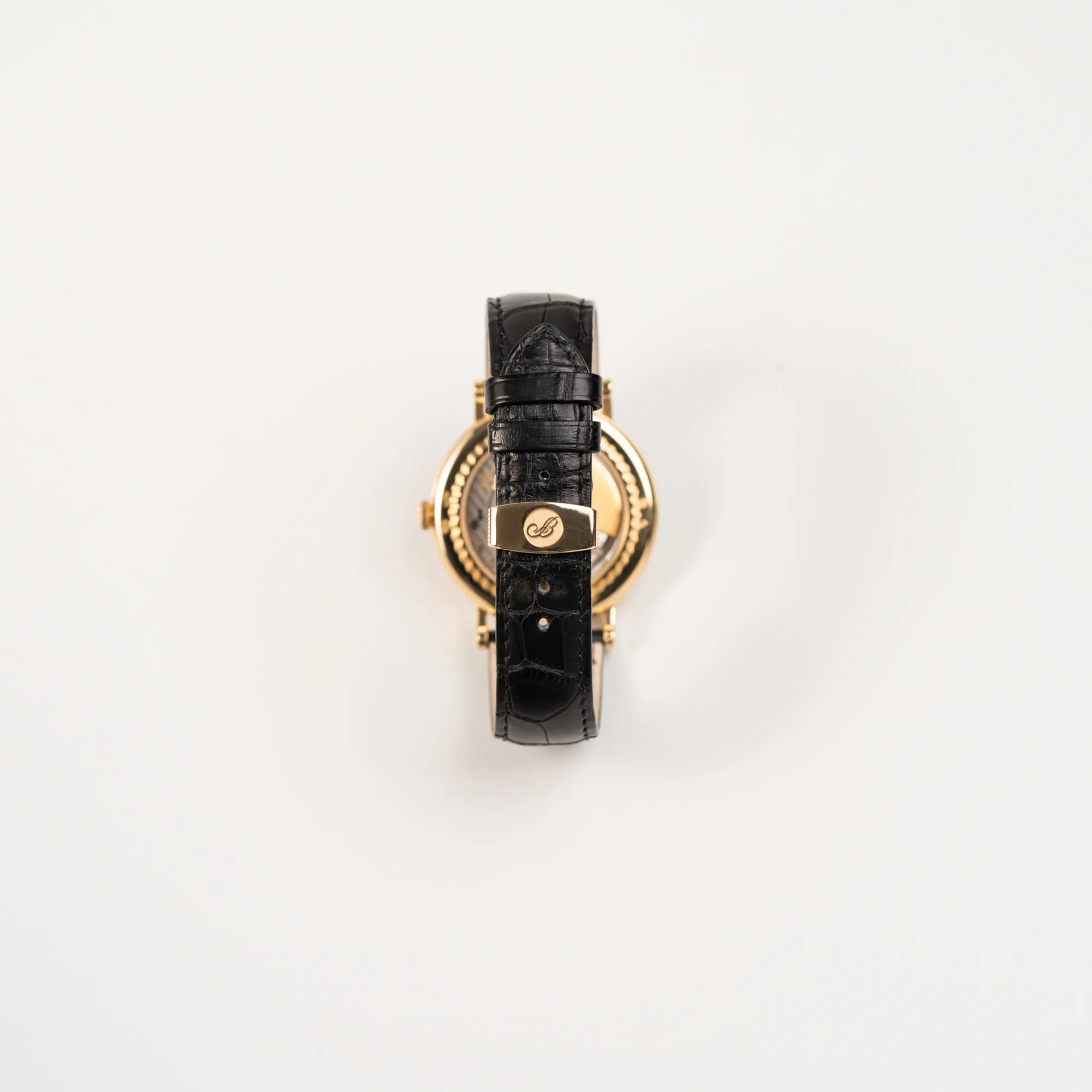 Blick auf das schwarze Lederband mit originaler Breguet-Gelbgold-Schliesse von der Breguet Classique 7137BA mit einem Gelbgoldgehäuse in klassischer Form mit einem silbernen Zifferblatt mit jeweils einem anderen handgefertigten Guilloche-Muster für jede Komplikation