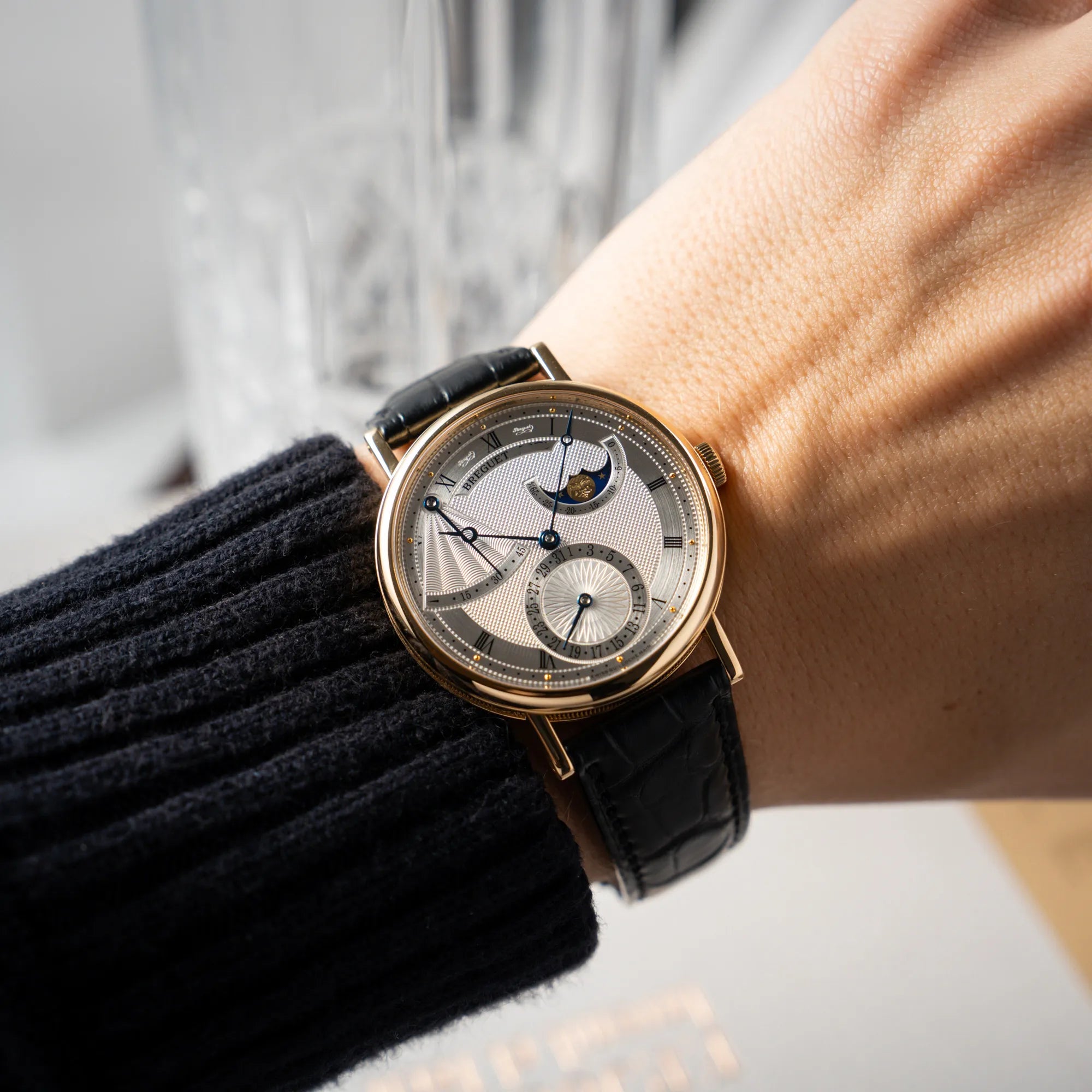 Mann trägt die Breguet Classique Mondphase 7137 in Gelbgold mit silbernen, verschieden guillochiertem Zifferblatt an seinem Arm