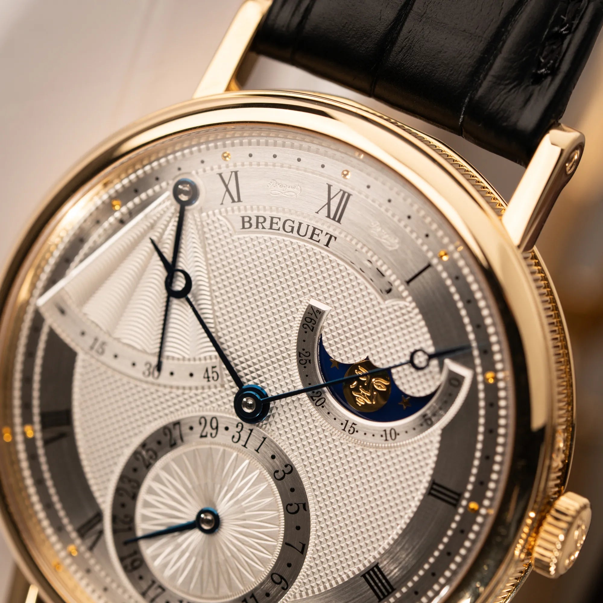 Detailaufnahme der Breguet Classique Mondphase 7137 in Gelbgold mit silbernen, verschieden guillochiertem Zifferblatt
