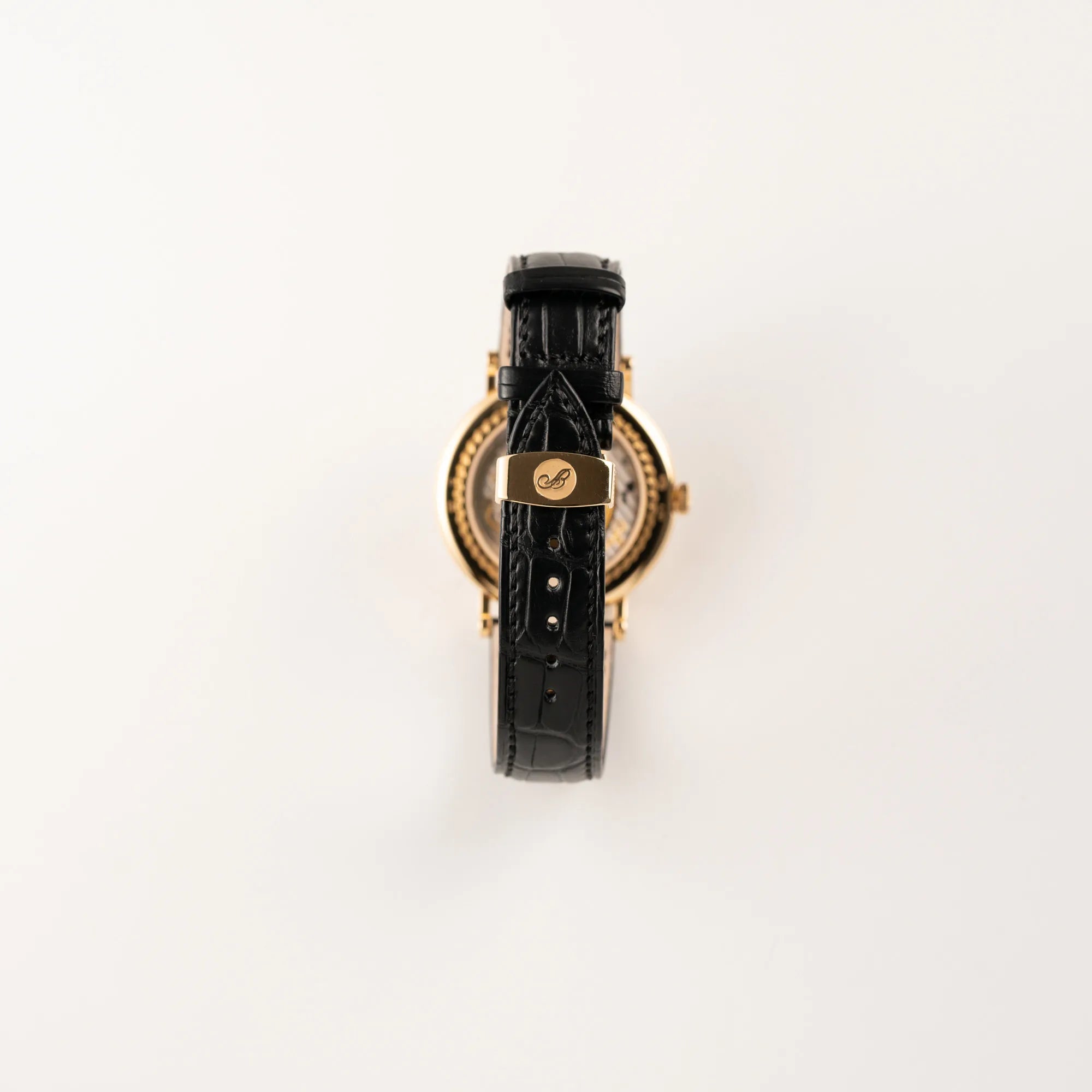 Blick auf das schwarze Lederband mit originaler Breguet-Goldschliesse der Breguet Classique Mondphase 7137 in Gelbgold mit silbernen, verschieden guillochiertem Zifferblatt