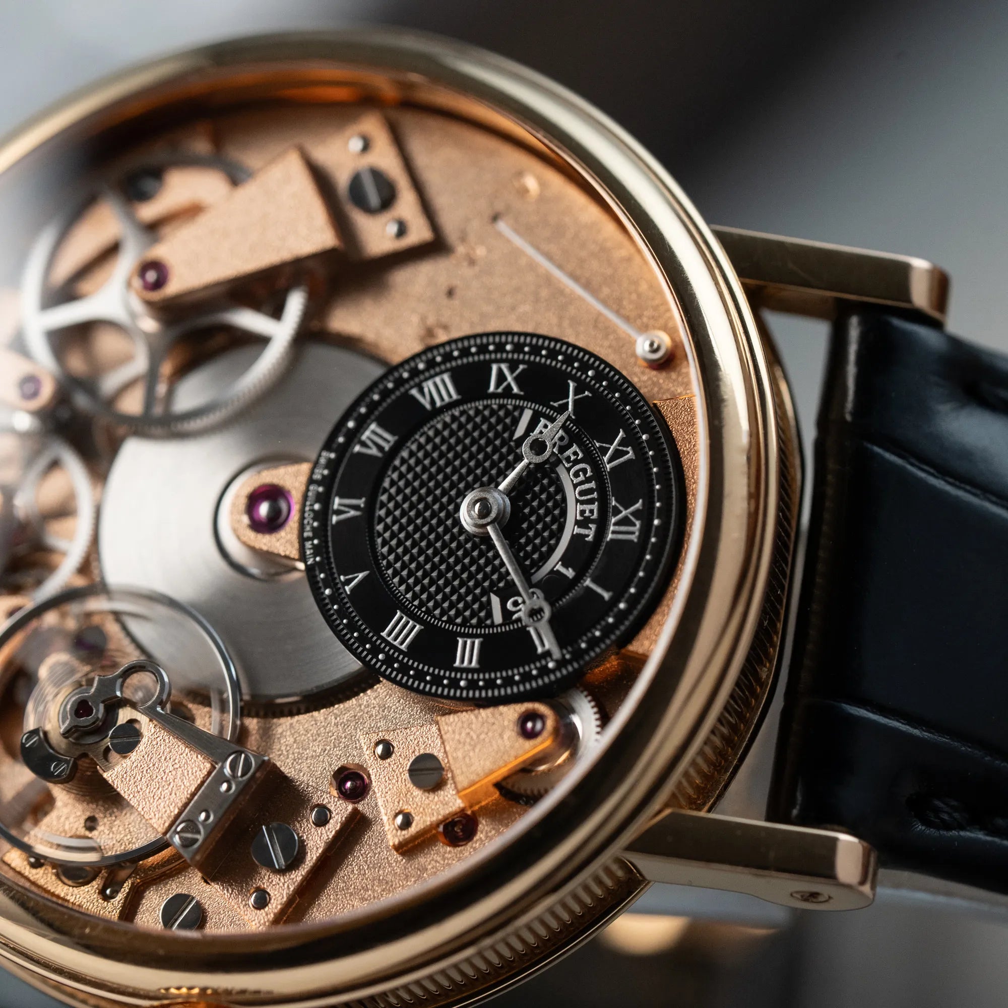Detailaufnahme der klassischen Breguet Tradition Armbanduhr mit Rosegold-Gehäuse und schwarzem Zifferblatt
