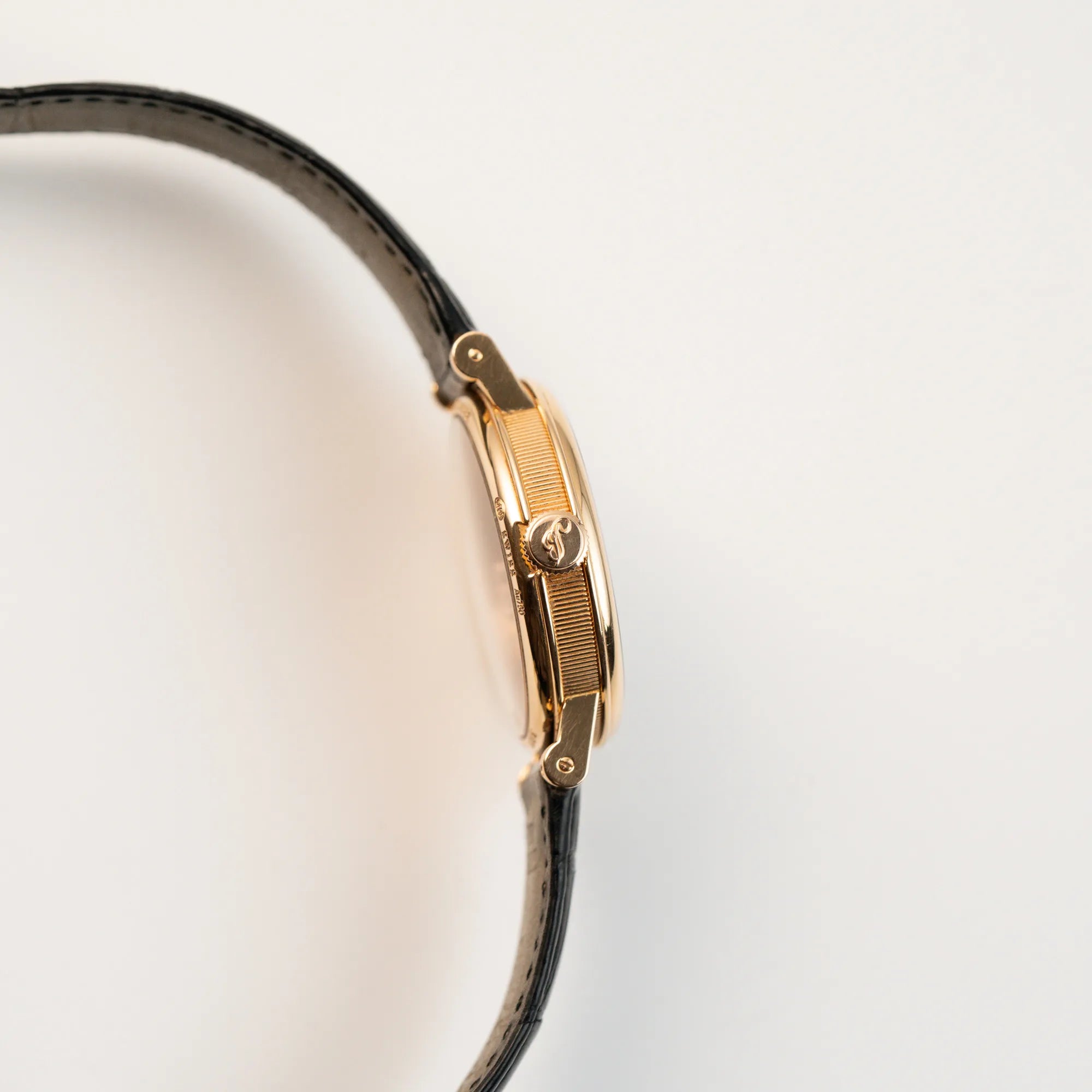 Seitliches Gehäuse der klassischen Breguet Tradition Armbanduhr mit Rosegold-Gehäuse und schwarzem Zifferblatt mit Blick auf die Aufzugskrone