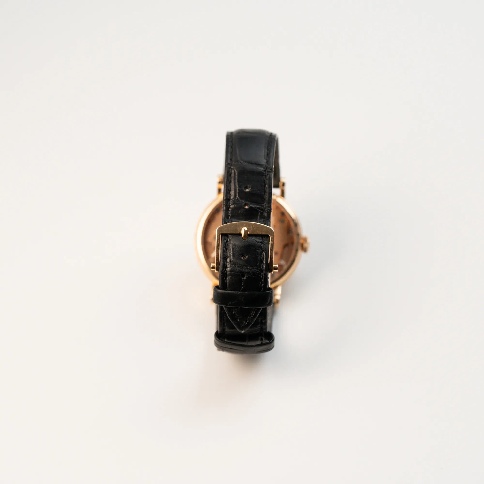 Blick auf die Rückseite (schwarzes Lederband mit Dornschlliesse) der klassischen Breguet Tradition Armbanduhr mit Rosegold-Gehäuse und schwarzem Zifferblatt