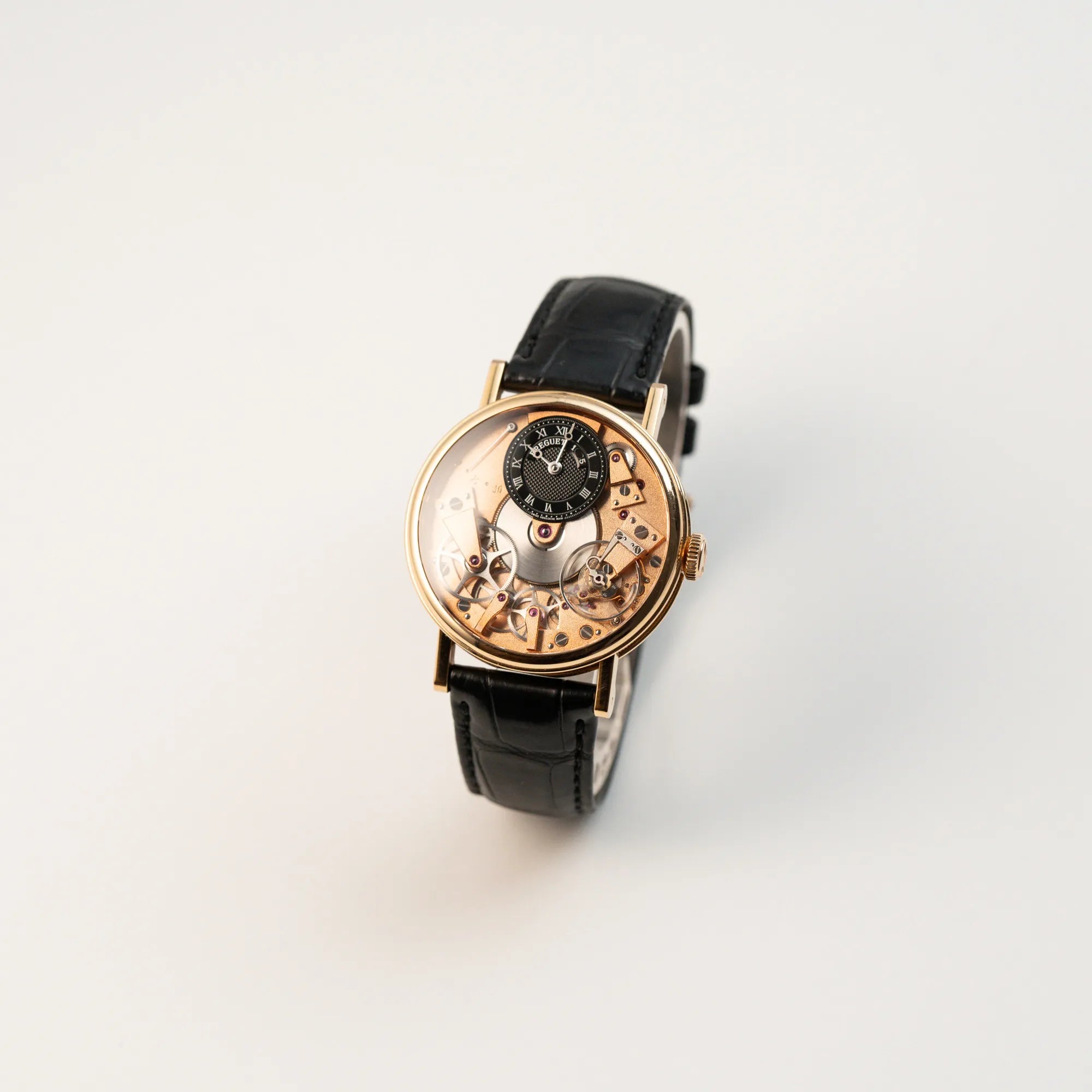 Leicht schräge Ansicht der klassischen Breguet Tradition Armbanduhr mit Rosegold-Gehäuse und schwarzem Zifferblatt