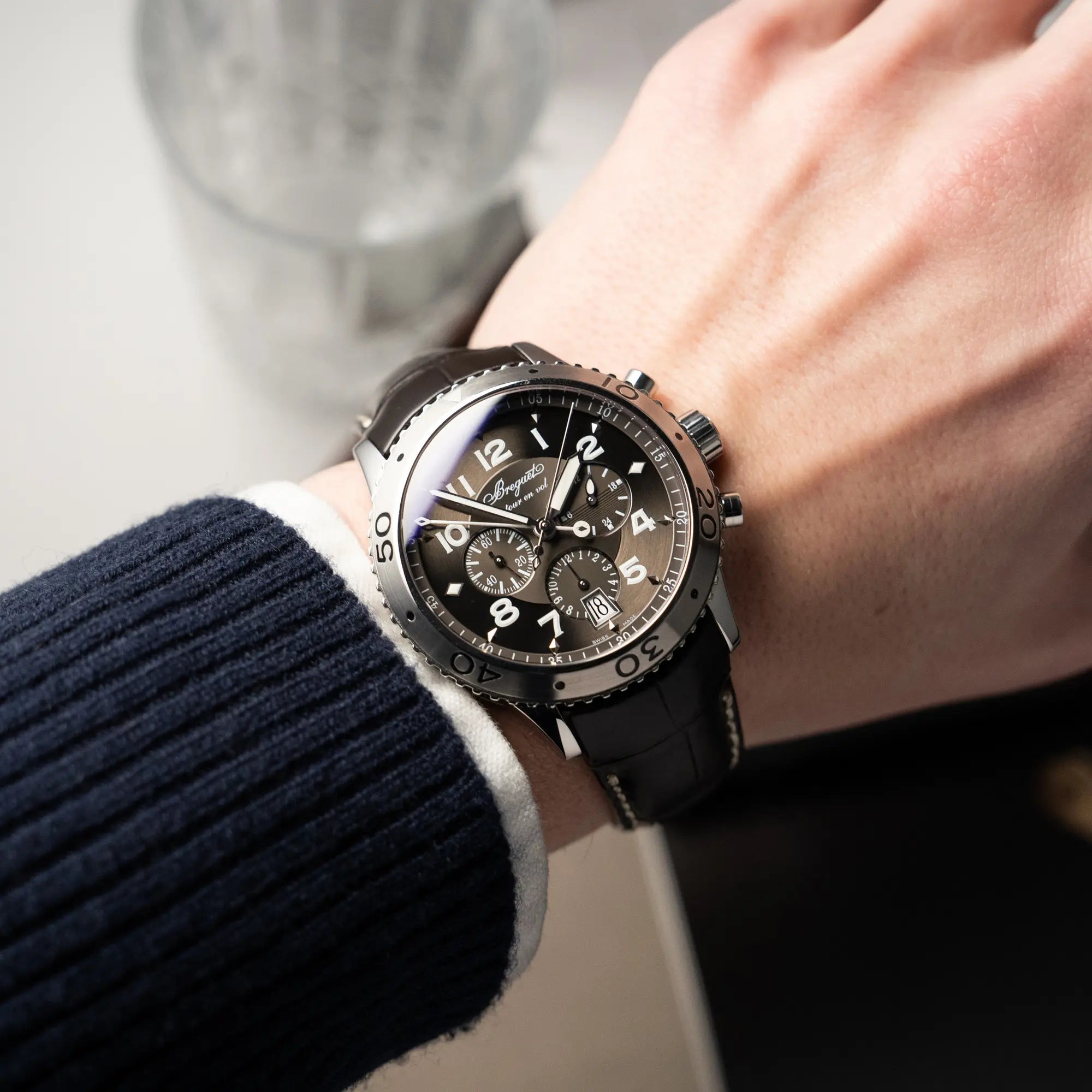 Mann trägt den Breguet Type XX Flyback Chronographen 3810ST mit braunem Zifferblatt an seinem Hangelenk