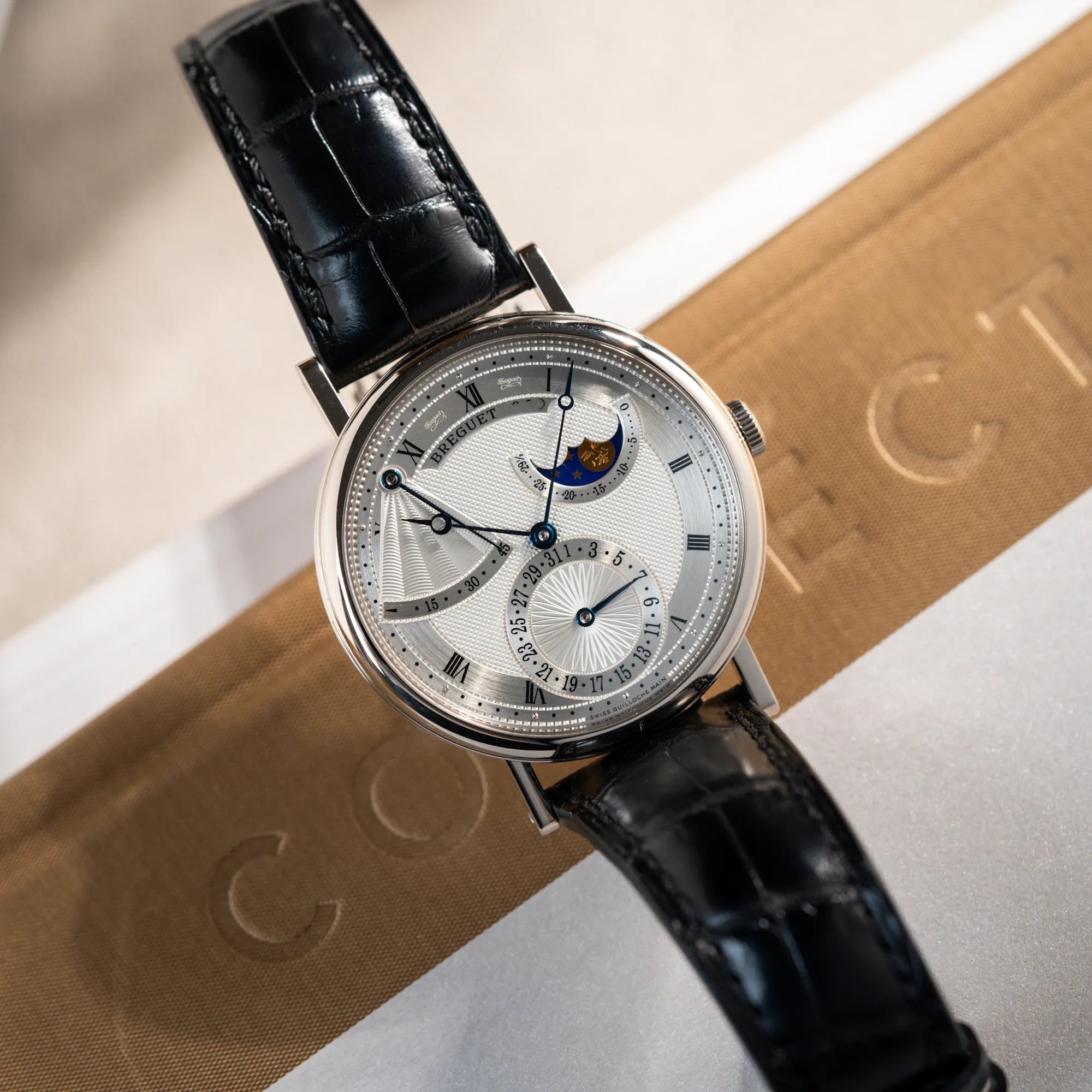 Produktfotografie der Breguet Classique Moonphase der Referenz 7137 in Weissgold mit 3-fach guillochiertem Zifferblatt und Mondphase-Anzeige aus der Voglperspektive