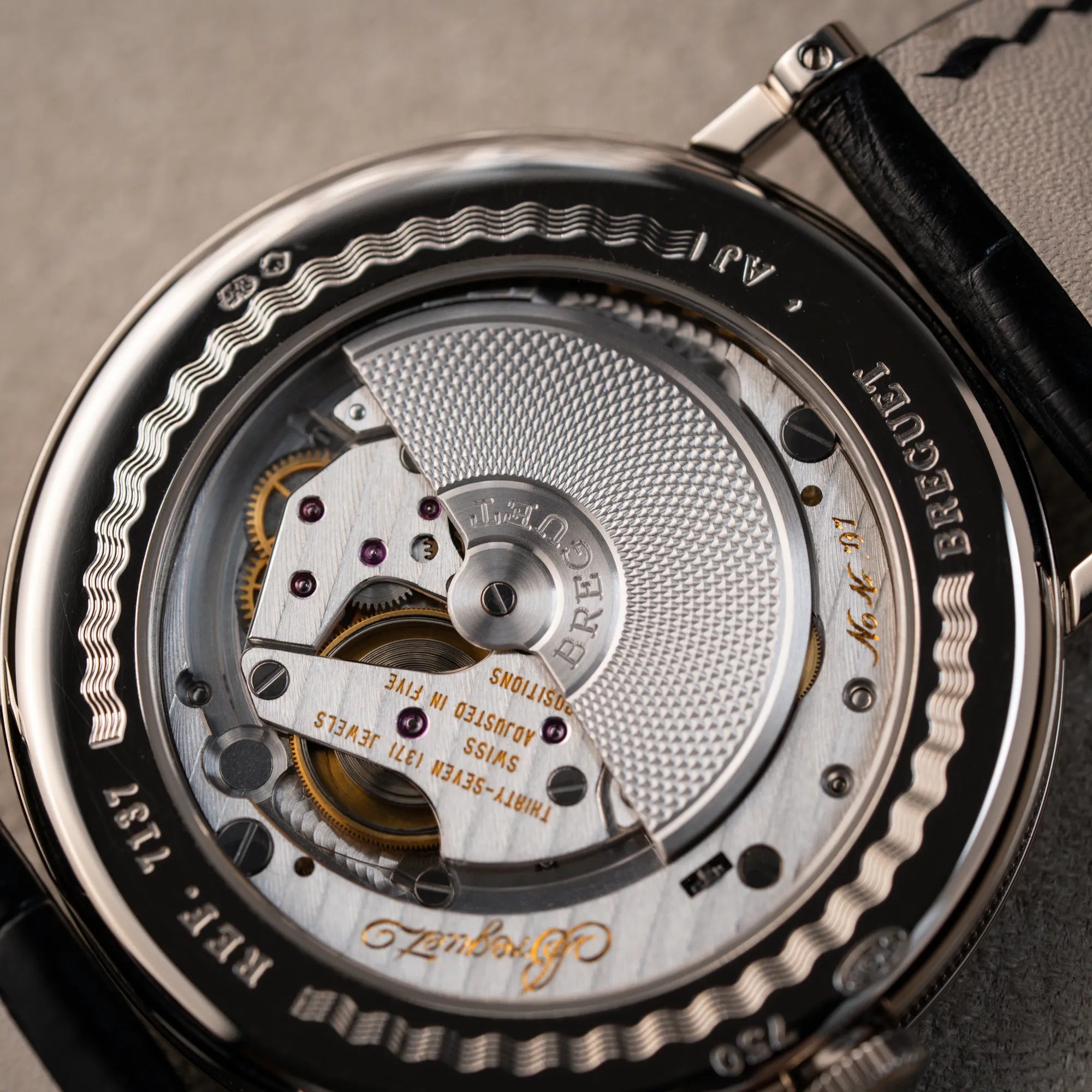 Detailaufnahme des Sichtbodens der Breguet Classique Moonphase der Referenz 7137 in Weissgold mit 3-fach guillochiertem Zifferblatt und Mondphase-Anzeige zeigt den Mikro-Rotor des Automatik-Uhrwerks 502.3 DR1