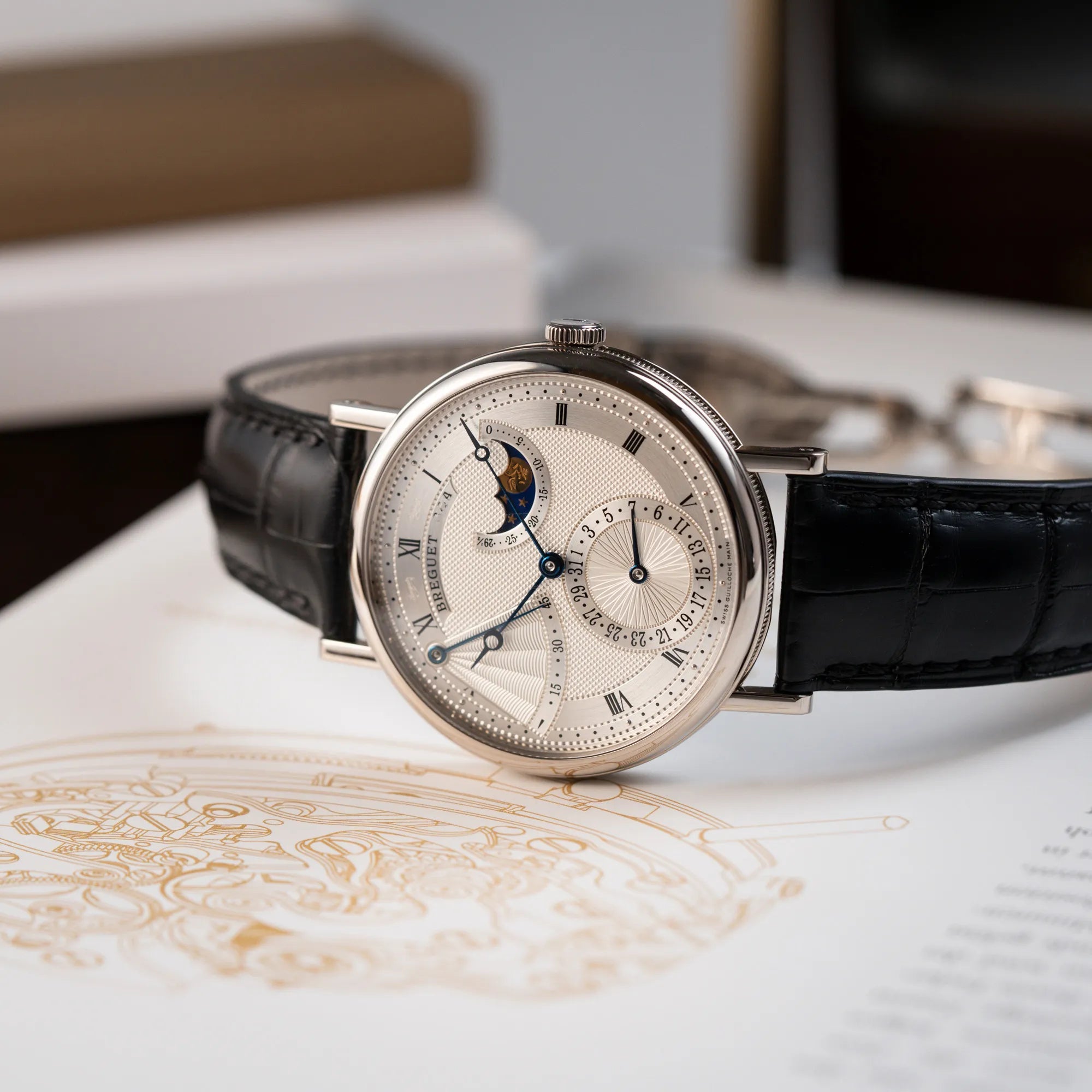 Fotografie der Breguet Classique Moonphase der Referenz 7137 in Weissgold mit 3-fach guillochiertem Zifferblatt und Mondphase-Anzeige