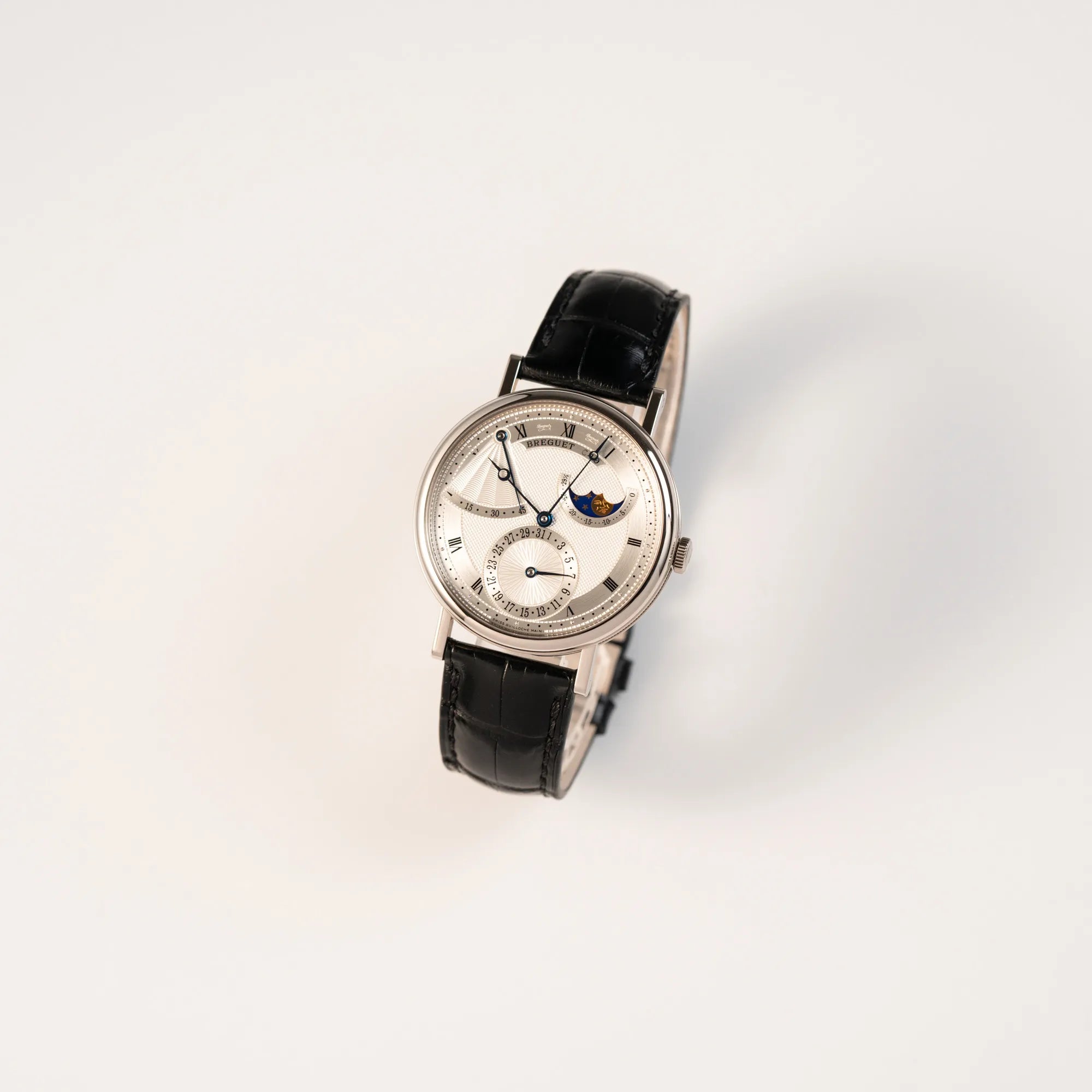 Leicht schräge Ansicht der Breguet Classique Moonphase der Referenz 7137 in Weissgold mit 3-fach guillochiertem Zifferblatt und Mondphase-Anzeige