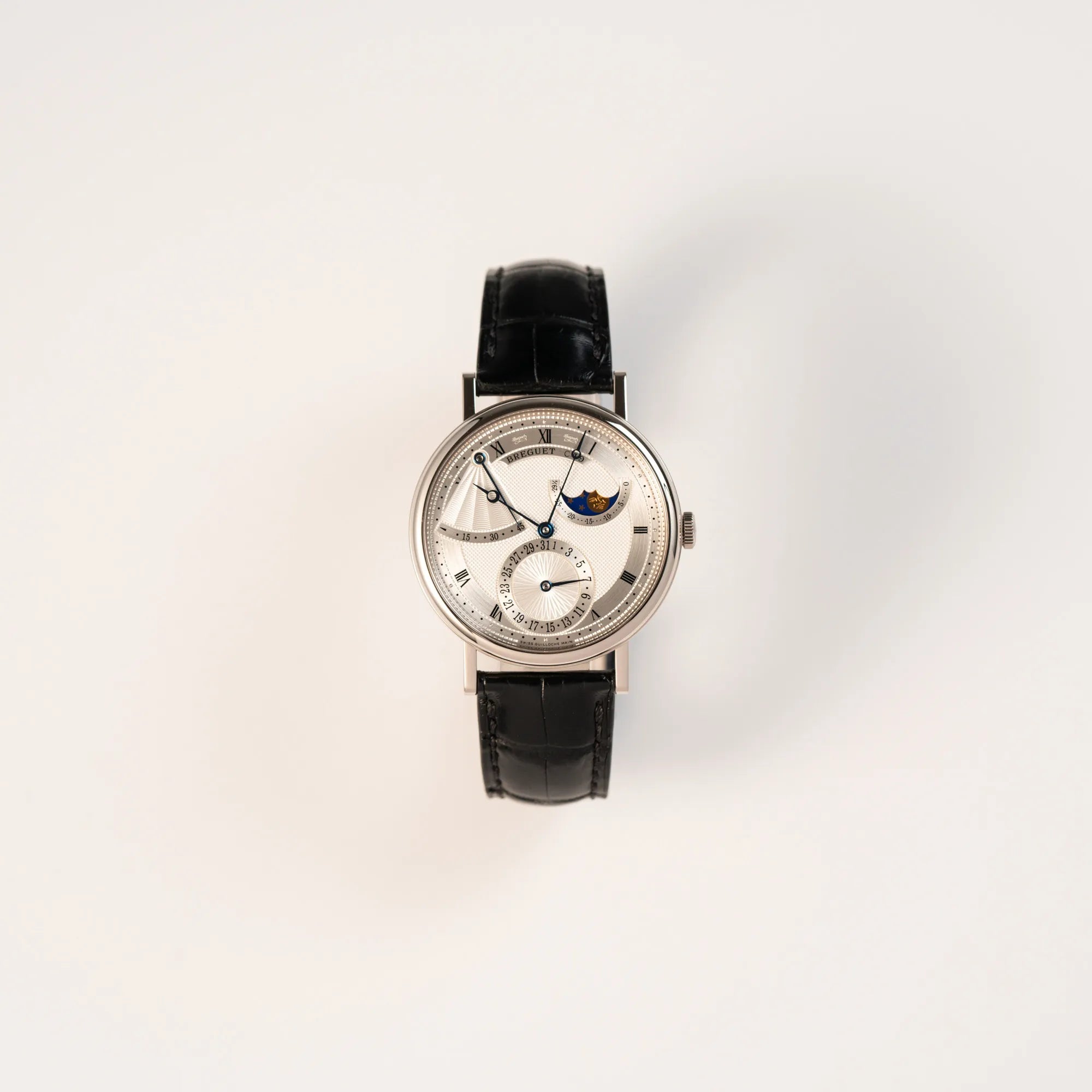 Frontale Ansicht der Breguet Classique Moonphase der Referenz 7137 in Weissgold mit 3-fach guillochiertem Zifferblatt und Mondphase-Anzeige