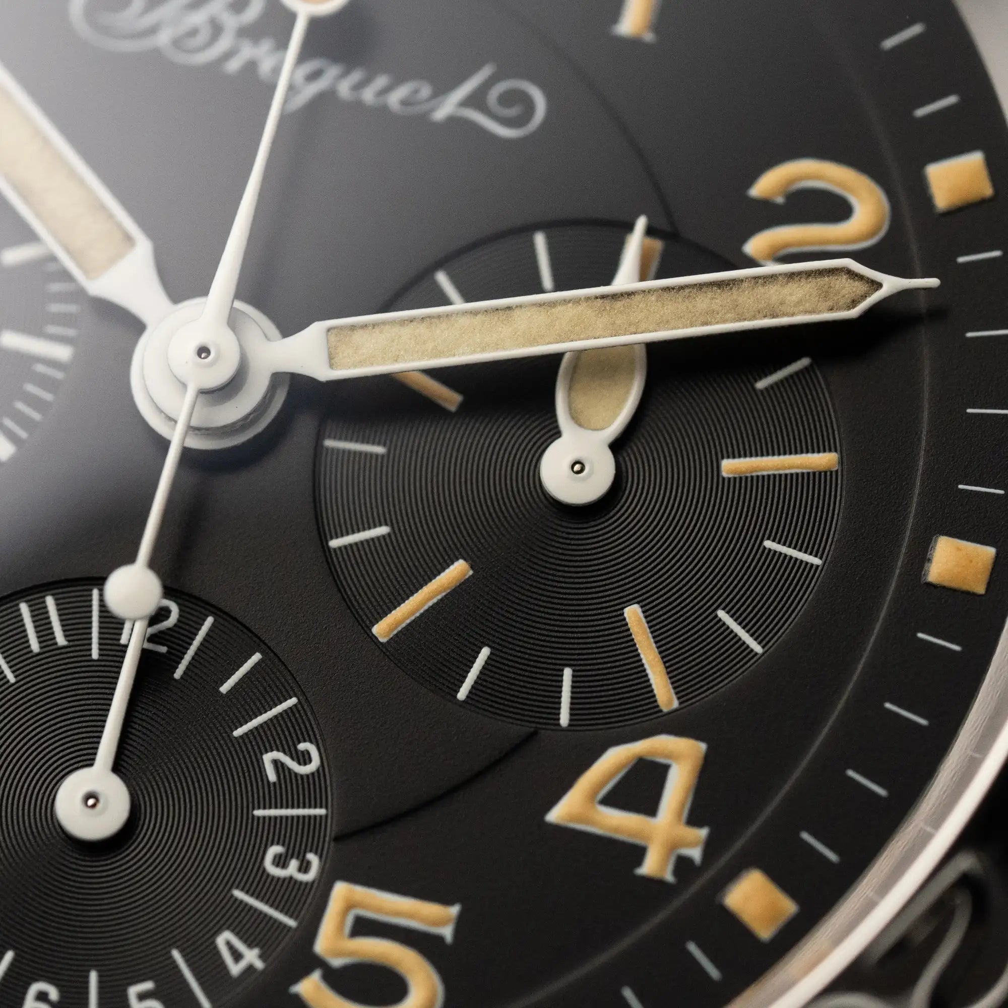 Macro-Aufnahme der Breguet Type XX Aéronavale mit der Referenz 3800ST und vergilbten Tritium-Zifferblatt am schwarzen Lederband