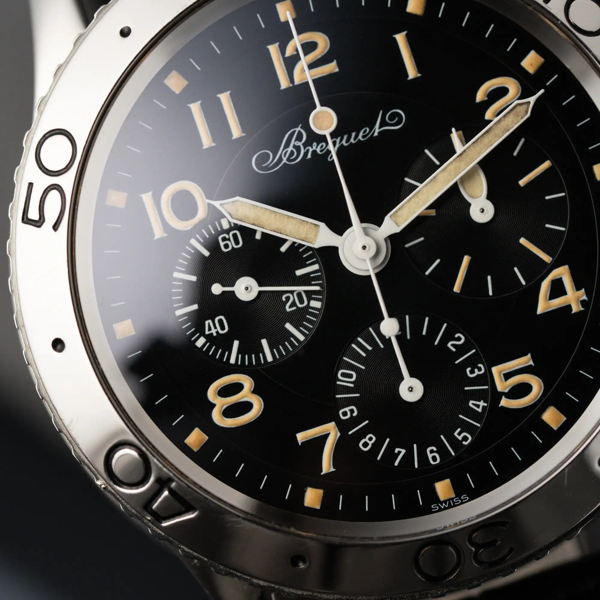 Nahaufnahme der Breguet Type XX Aéronavale mit der Referenz 3800ST und vergilbten Tritium-Zifferblatt am schwarzen Lederband
