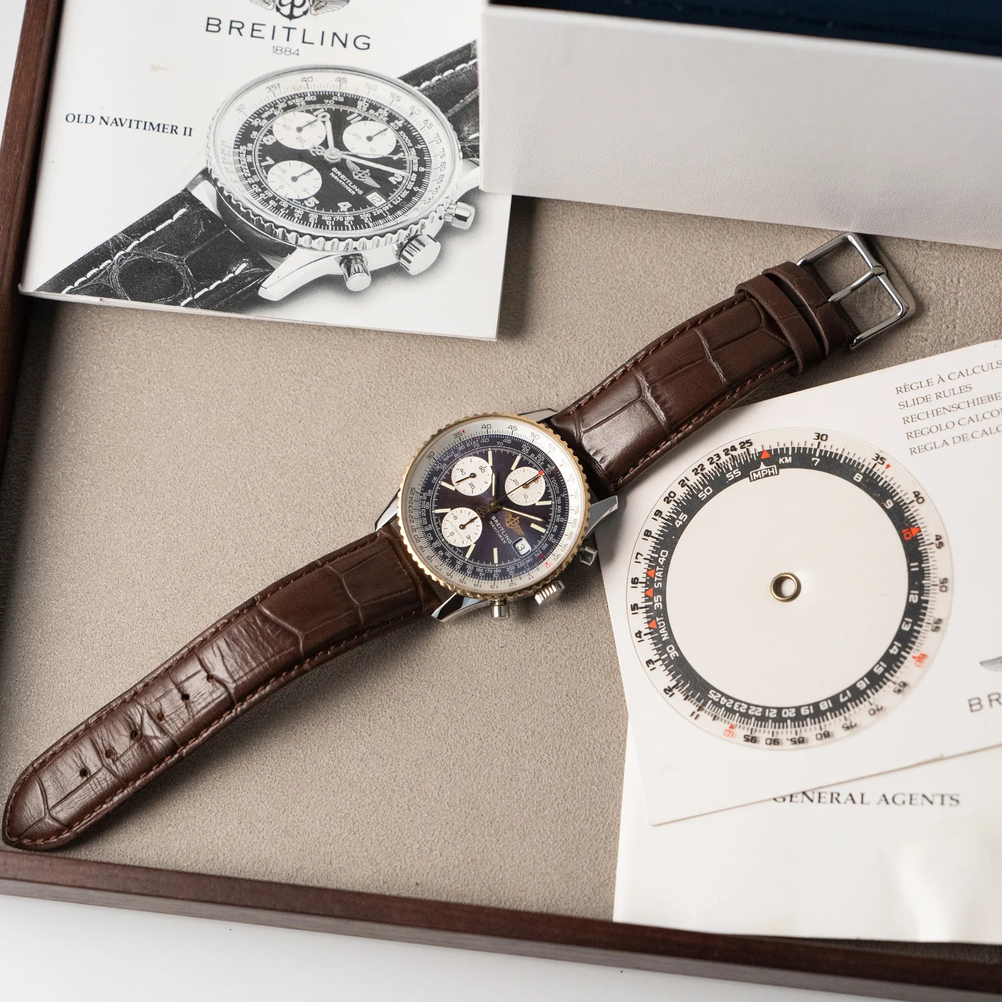 Fotografie des Breitling Old Navitimers mit Stahl-Gold-Gehäuse am braunen Lederband mit passenden Booklets