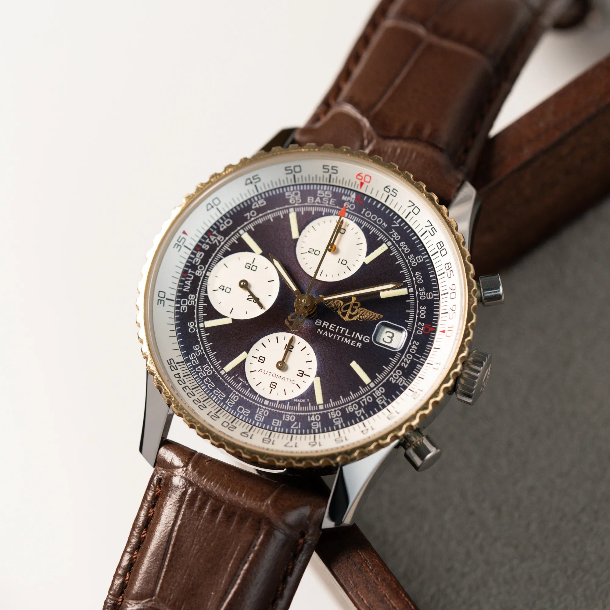 Detailaufnahme des Breitling Old Navitimers mit Stahl-Gold-Gehäuse am braunen Lederband