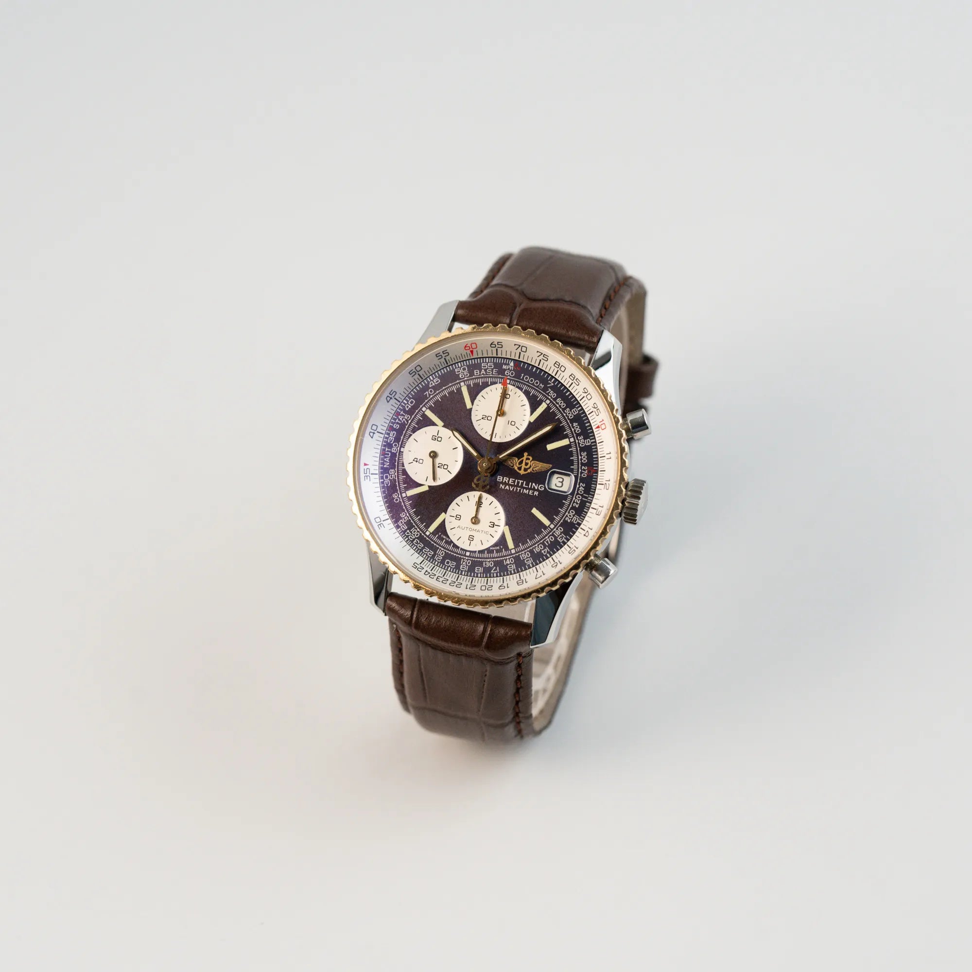 Leicht schräge Ansicht des Breitling Old Navitimers mit Stahl-Gold-Gehäuse am braunen Lederband