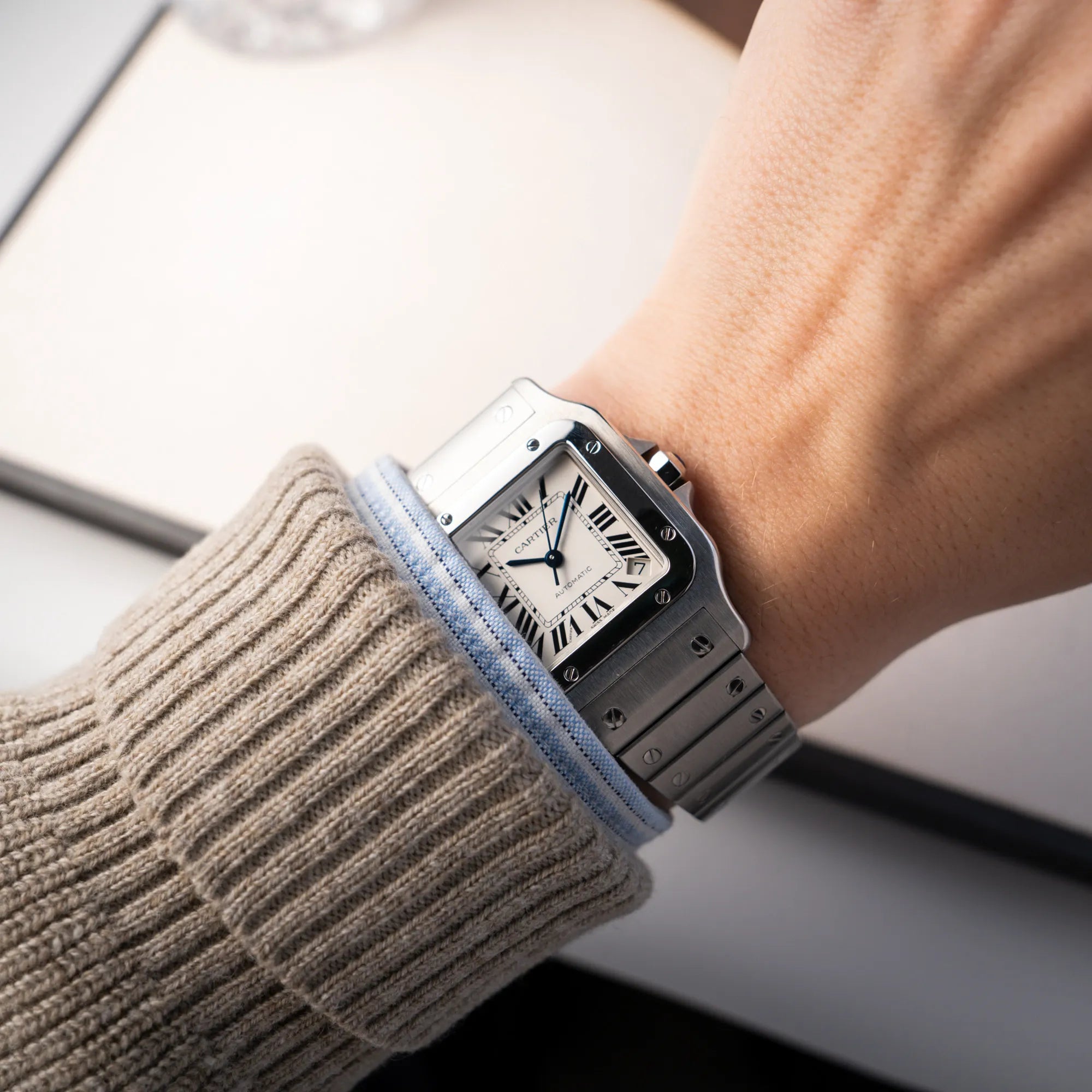 Wristshot mit der Cartier Santos Galbée 2823 in Edelstahl mit weißem Zifferblatt an einem Männerhandgelenk