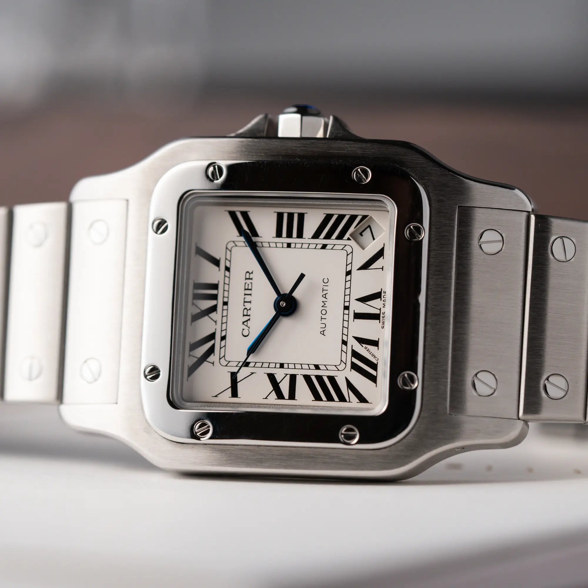Detailaufnahme des Uhrenkopfes von der Cartier Santos Galbée 2823 in Edelstahl mit weißem Zifferblatt