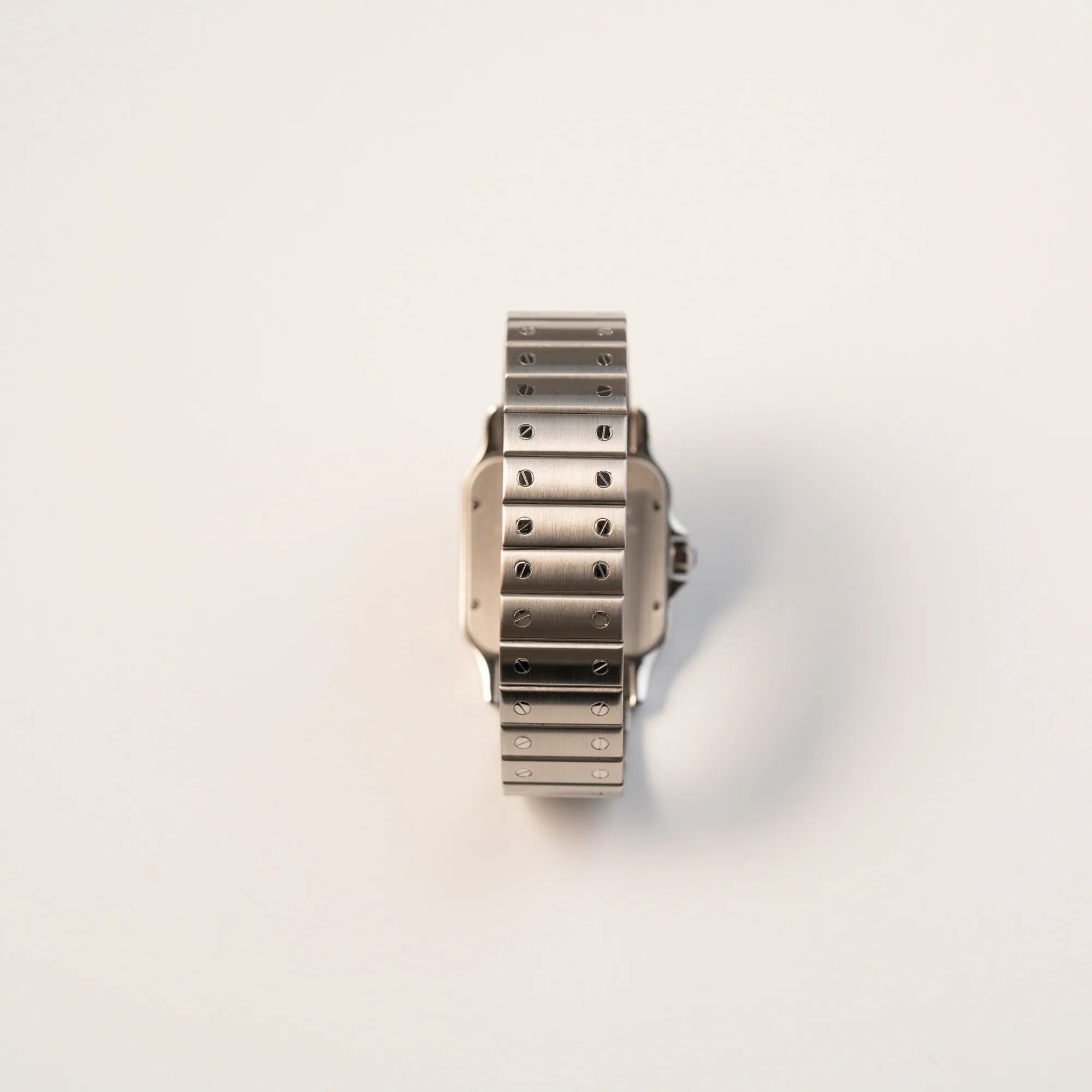 Blick auf das typische Cartier-Armband mit angedeuteten Schrauben von der Cartier Santos Galbée 2823 in Edelstahl mit weißem Zifferblatt