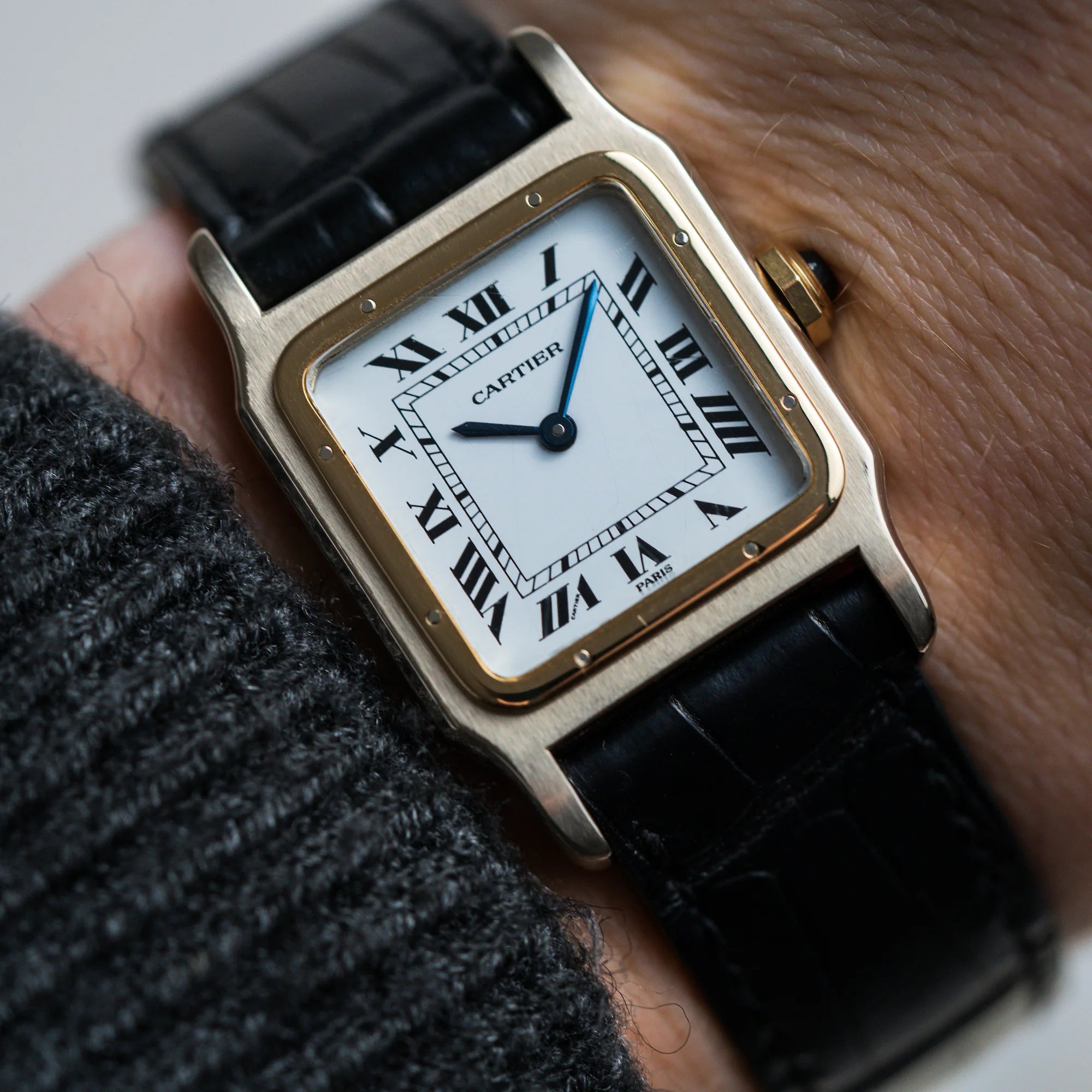 Detailaufnahme des Handgelenks eines Mannes mit der Cartier Santos Dumont "Deux Ors" mit Paris weißem Paris Dial