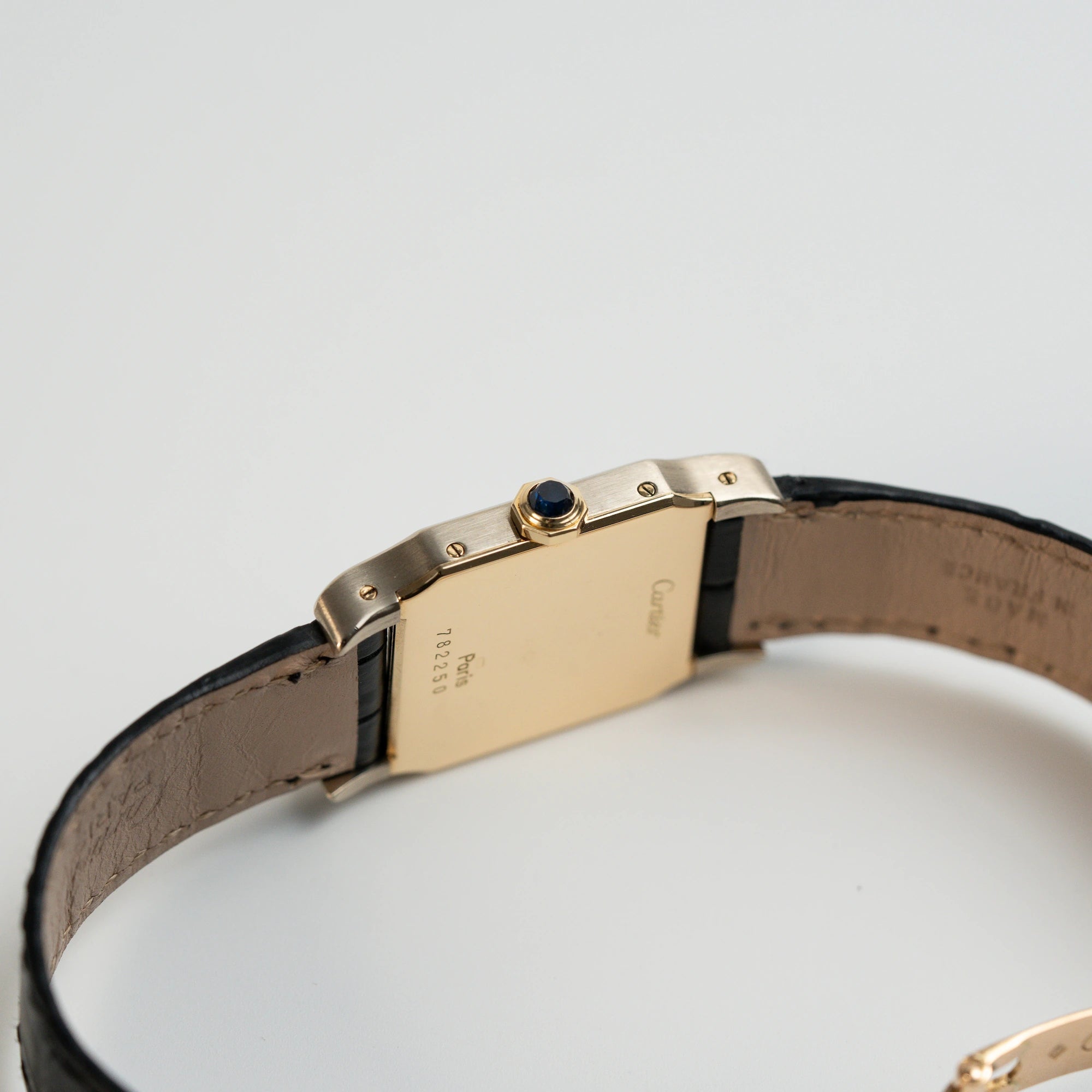 Gehäuseboden und seitliches Gehäuse mit Krone der Cartier Santos Dumont "Deux Ors" mit Paris Dial am schwarzen Lederarmband