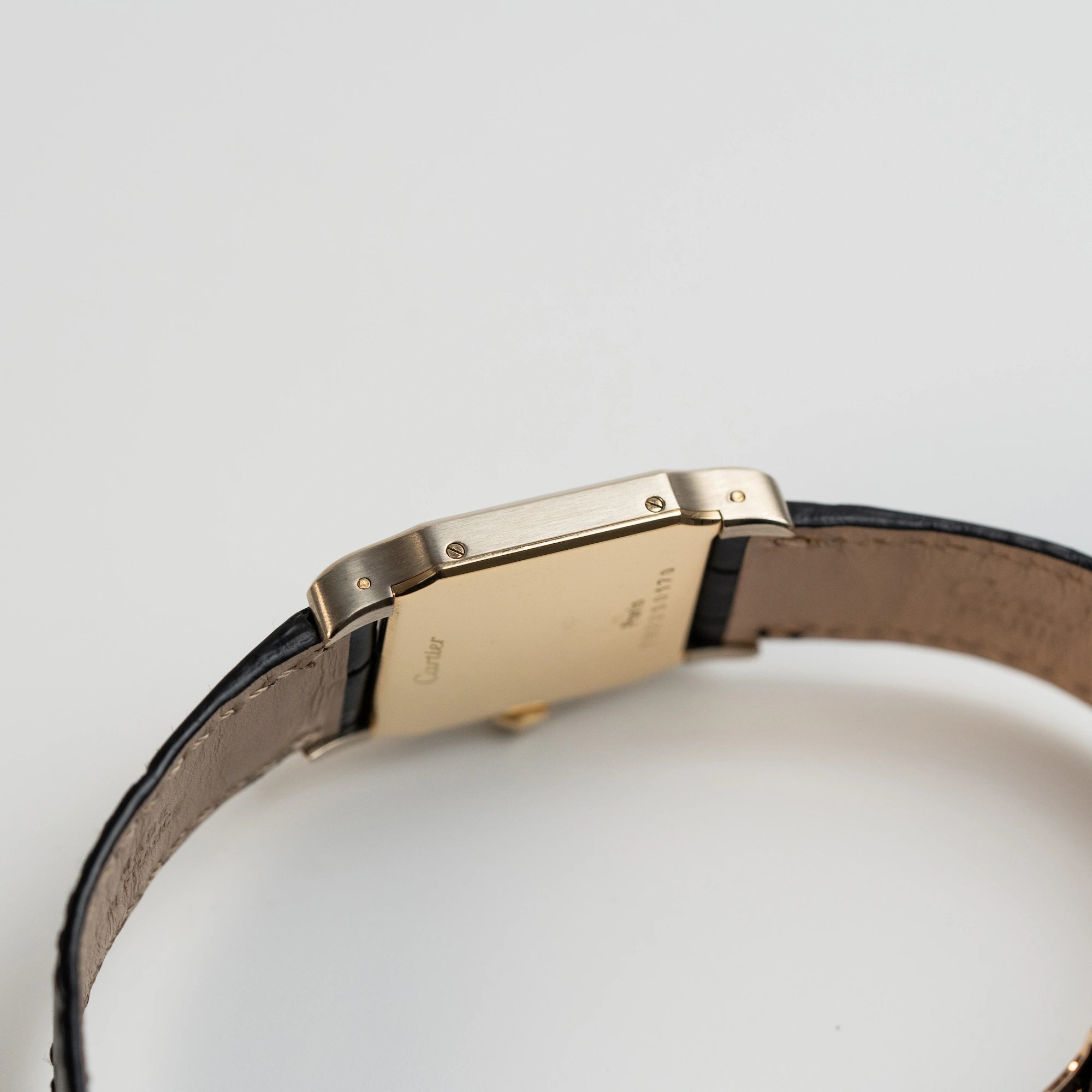 Seitliches Gehäuse der Cartier Santos Dumont "Deux Ors" mit Paris Dial am schwarzen Lederarmband
