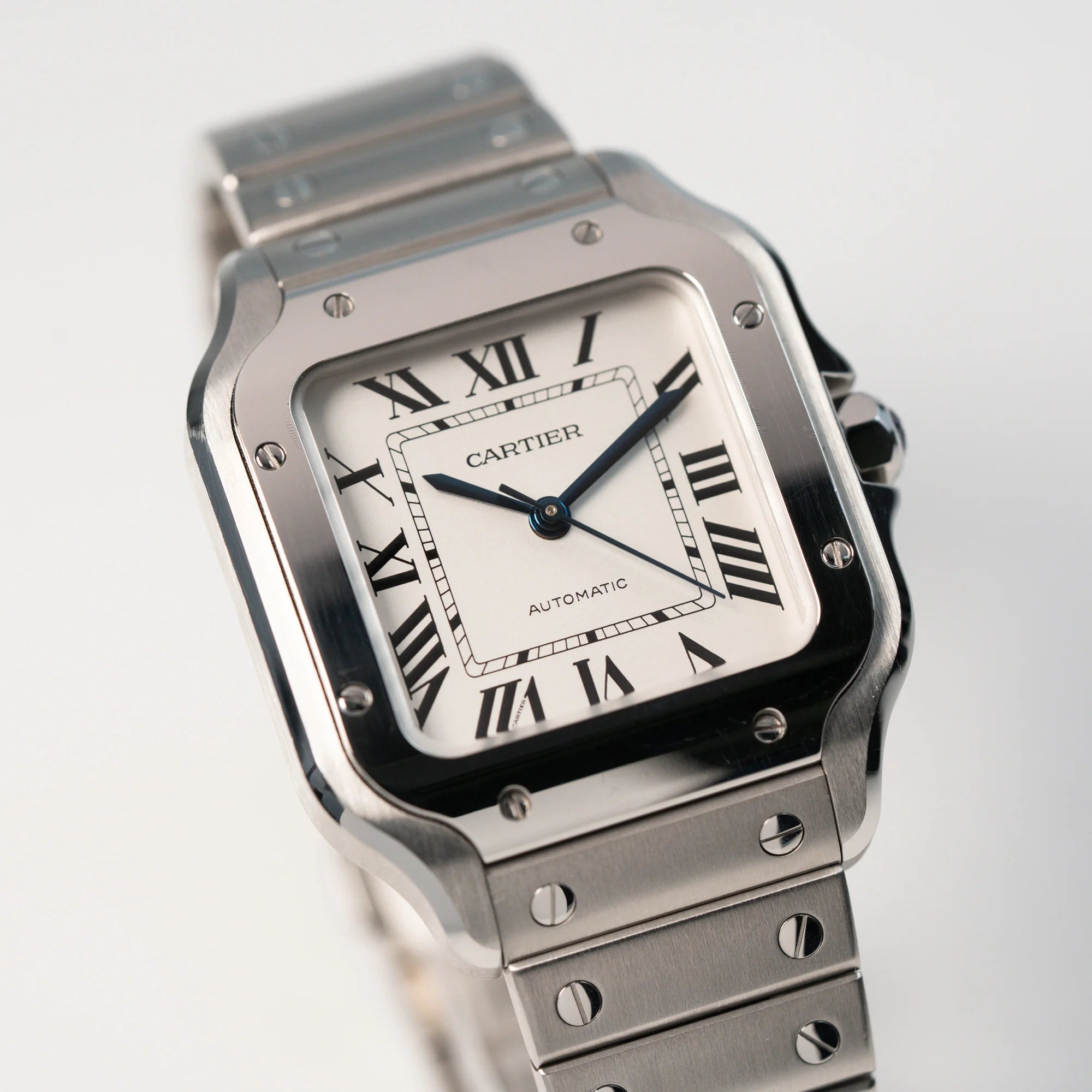 Detailaufnahme der Cartier Santos Medium mit dem klassischen weißen Zifferblatt mit römischen Indizes